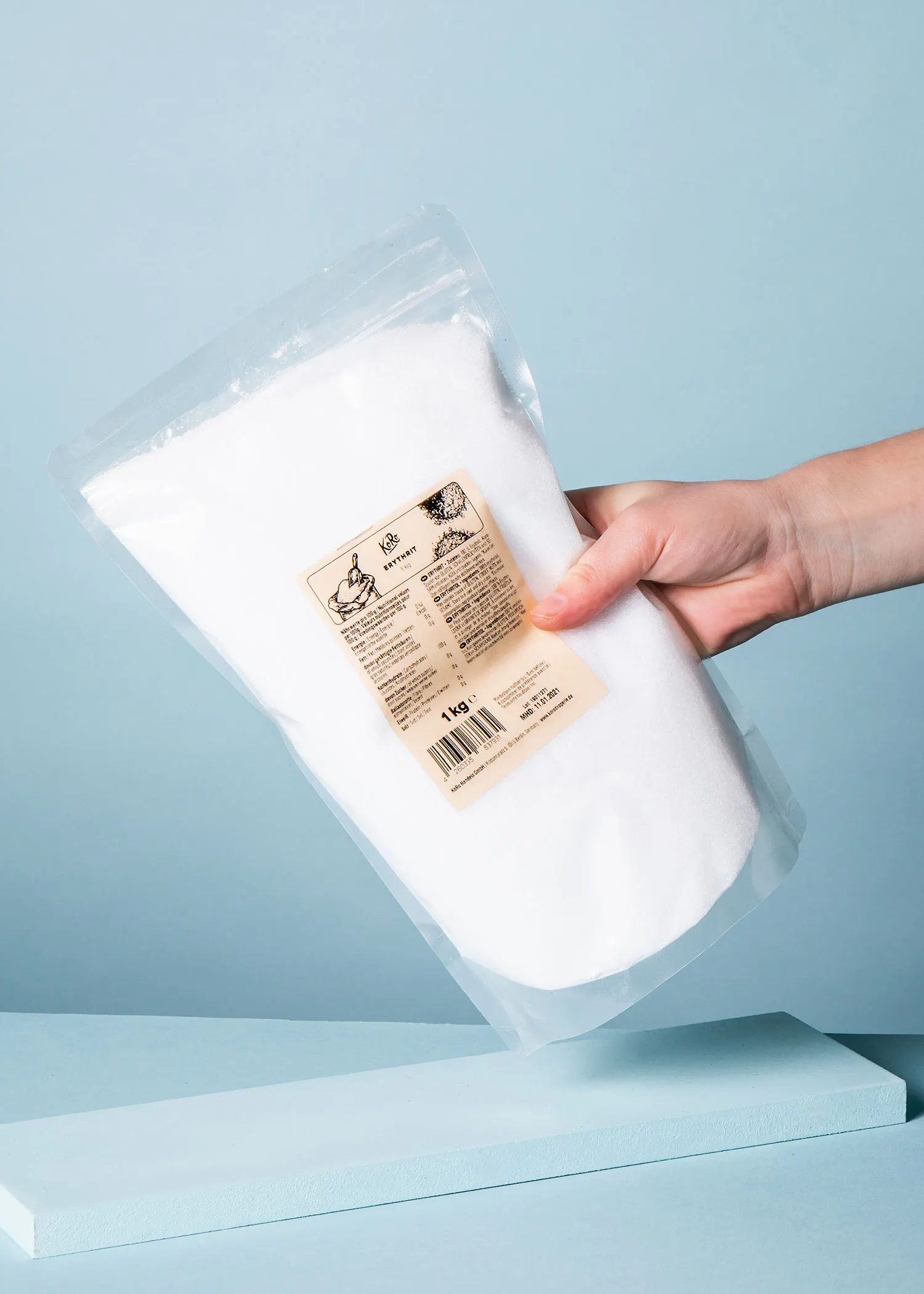 a person is holding a bag of powder that says 1kg