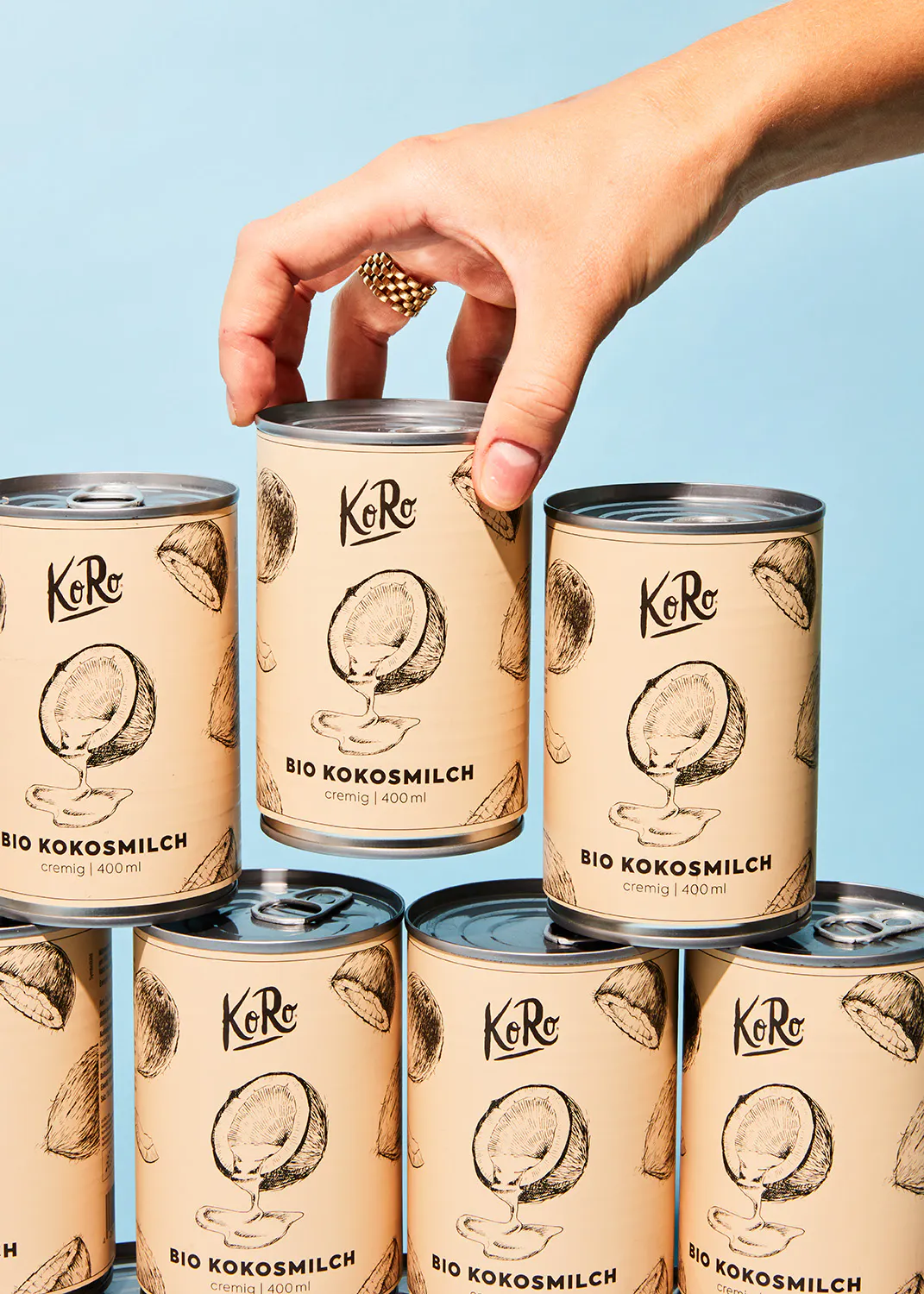 une personne tient une canette de lait de coco bio koro