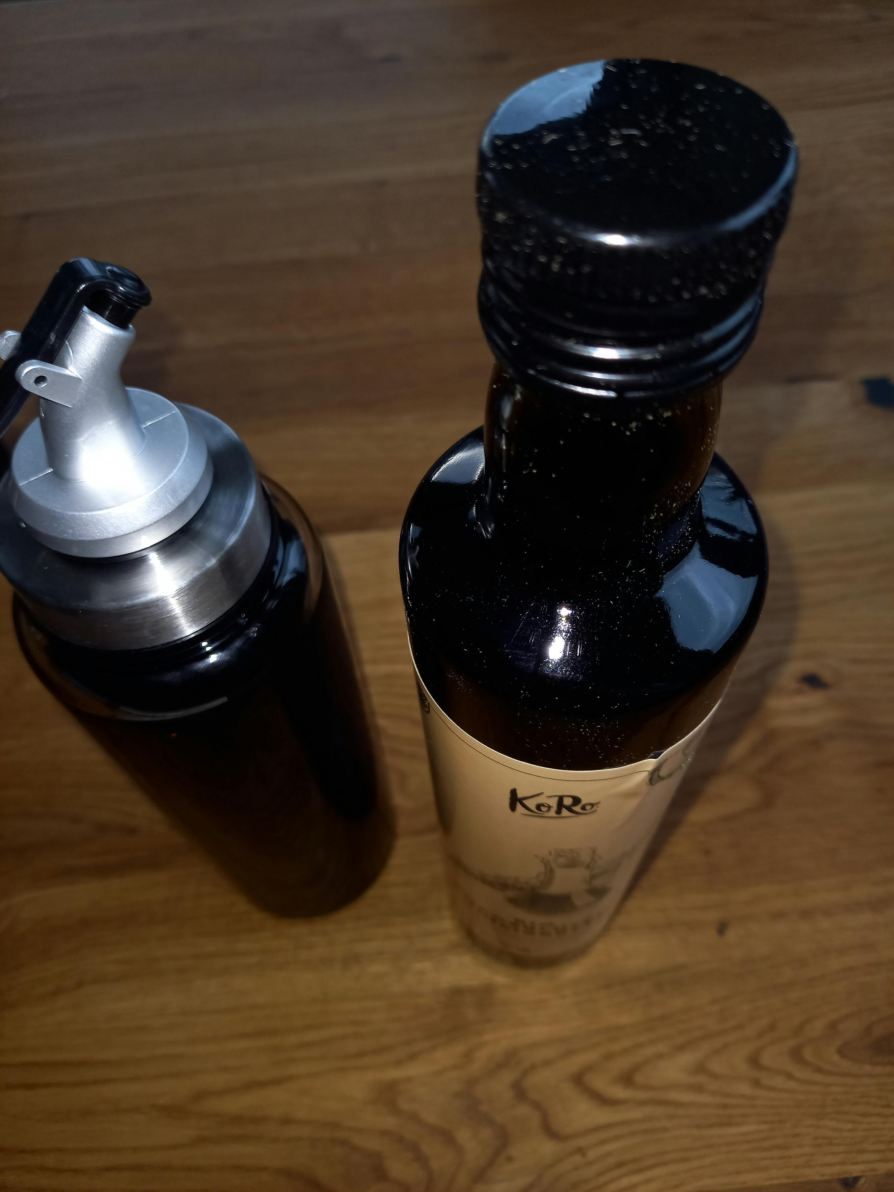 due bottiglie di k & r si trovano su un tavolo di legno