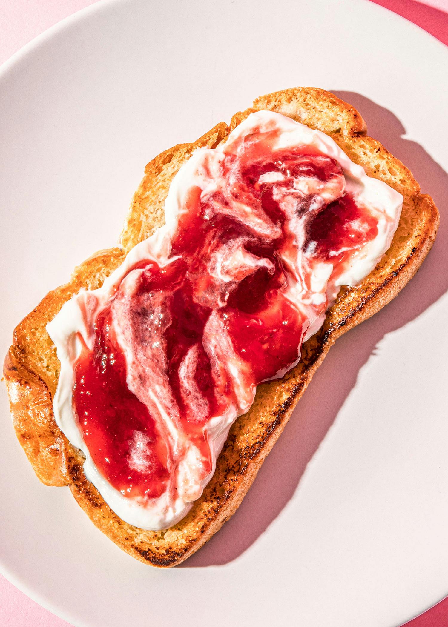 a slice of toast with whipped cream and strawberry jam on it