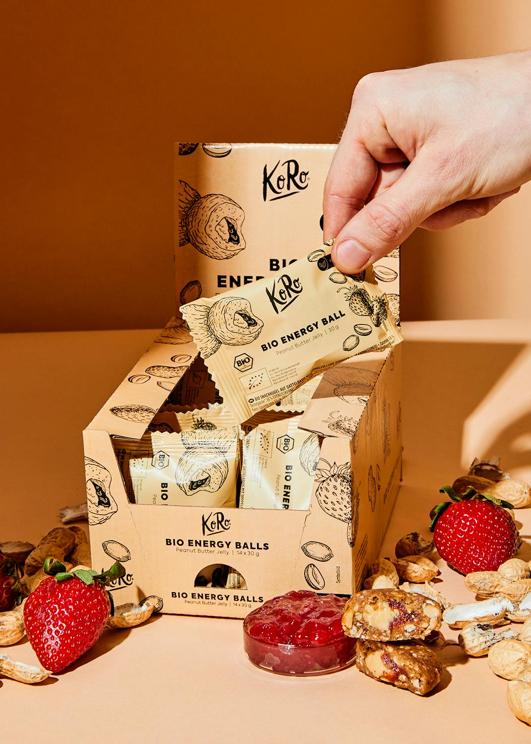 a box of bio energy balls with strawberries and nuts