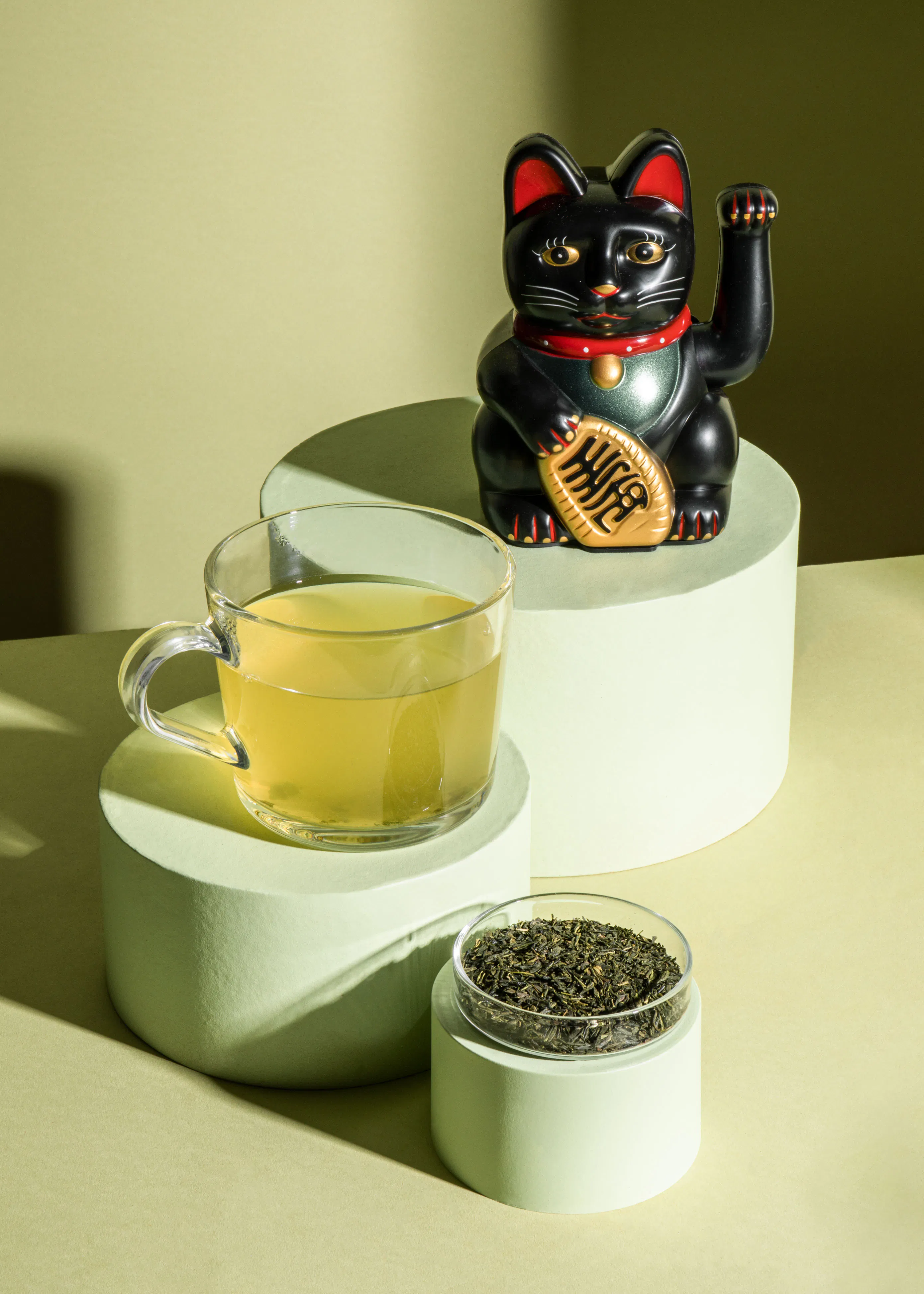 eine glückskatze steht neben einer tasse tee