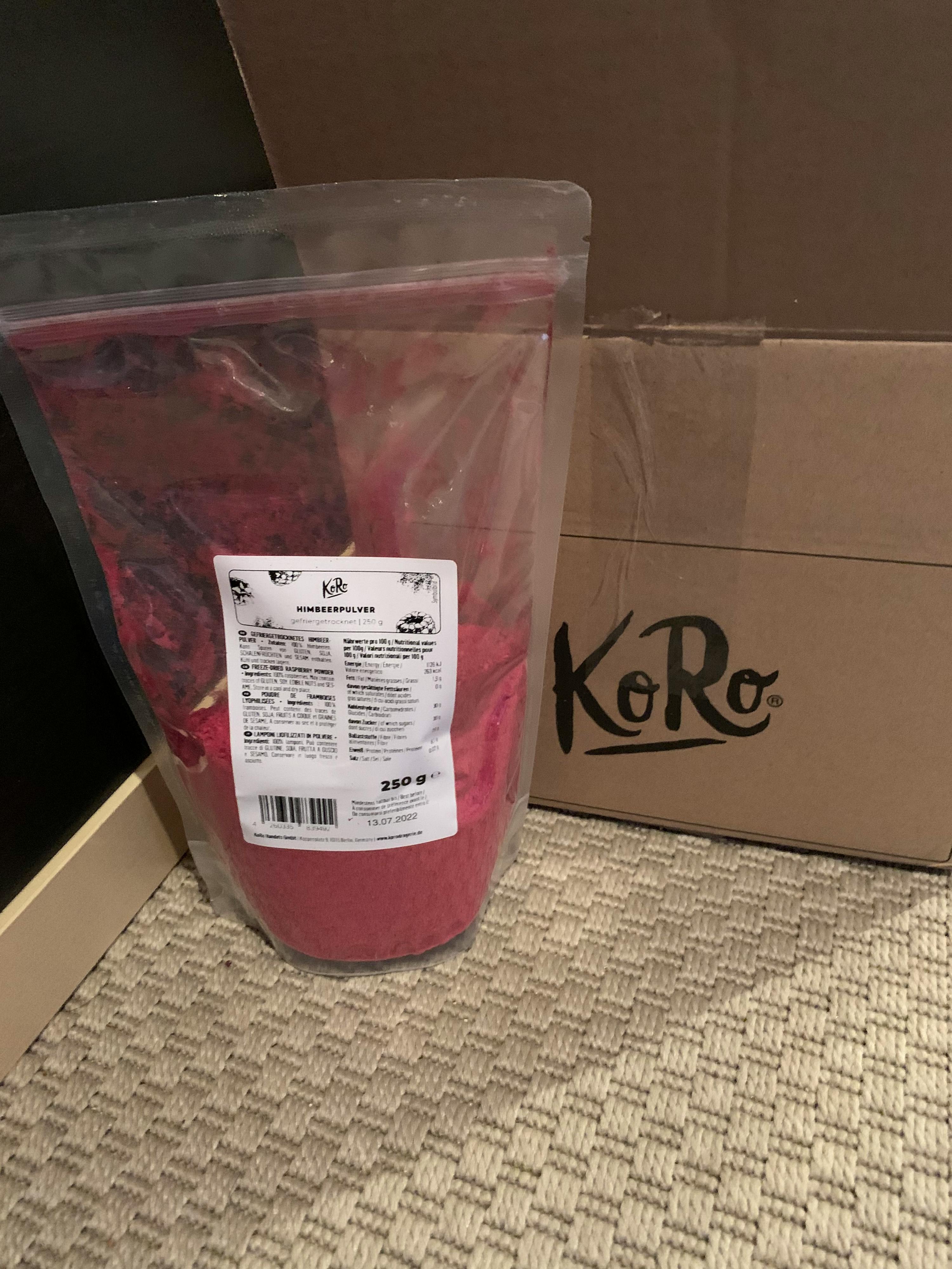 a bag of red powder next to a cardboard box that says koro