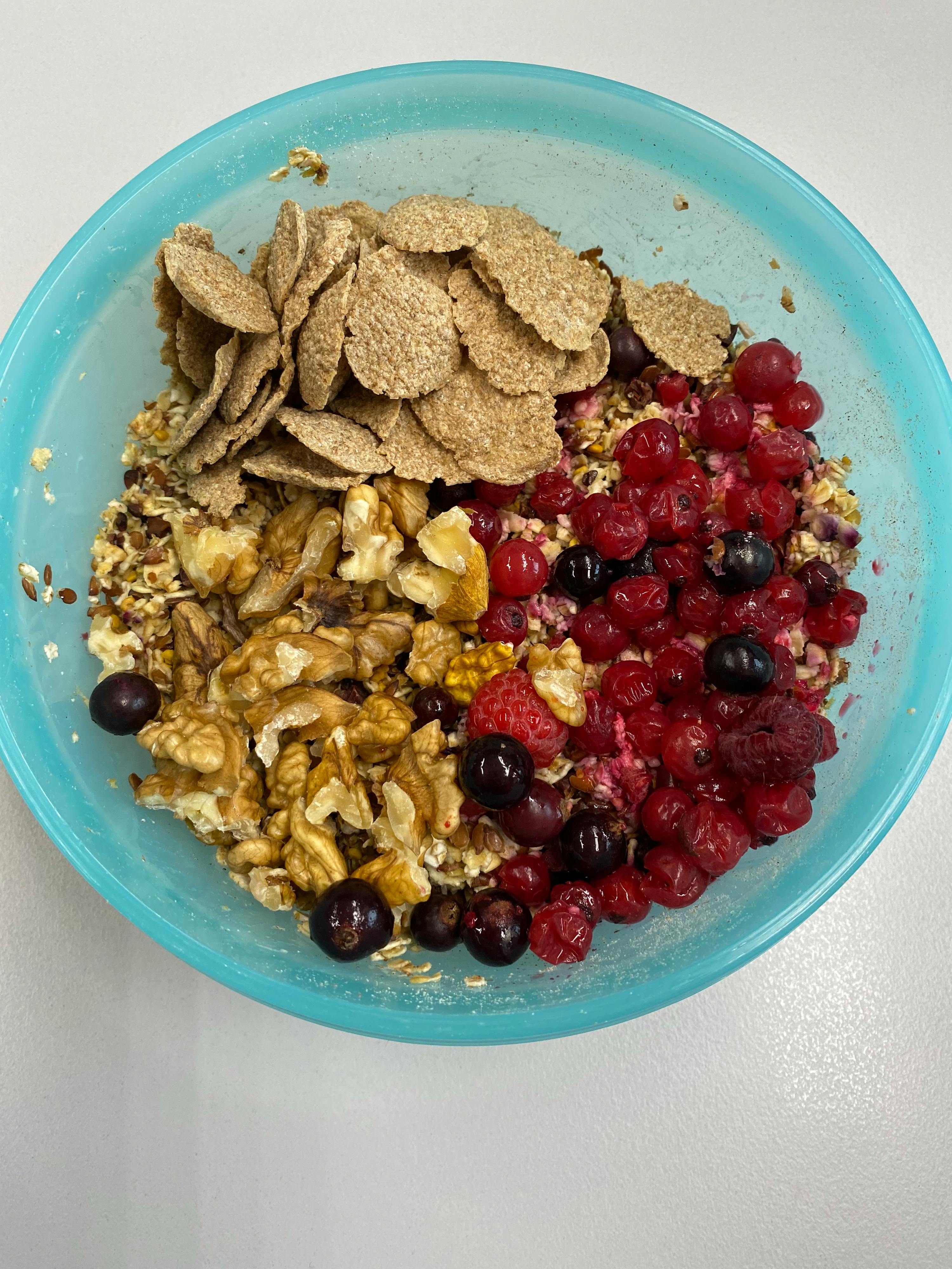eine blaue Schüssel mit Müsli , Walnüsse und Beeren