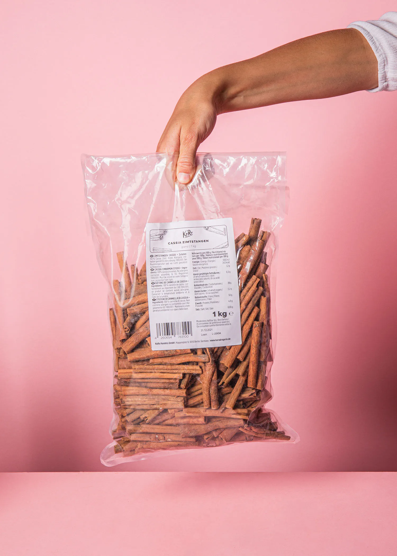 a person is holding a plastic bag of cinnamon sticks