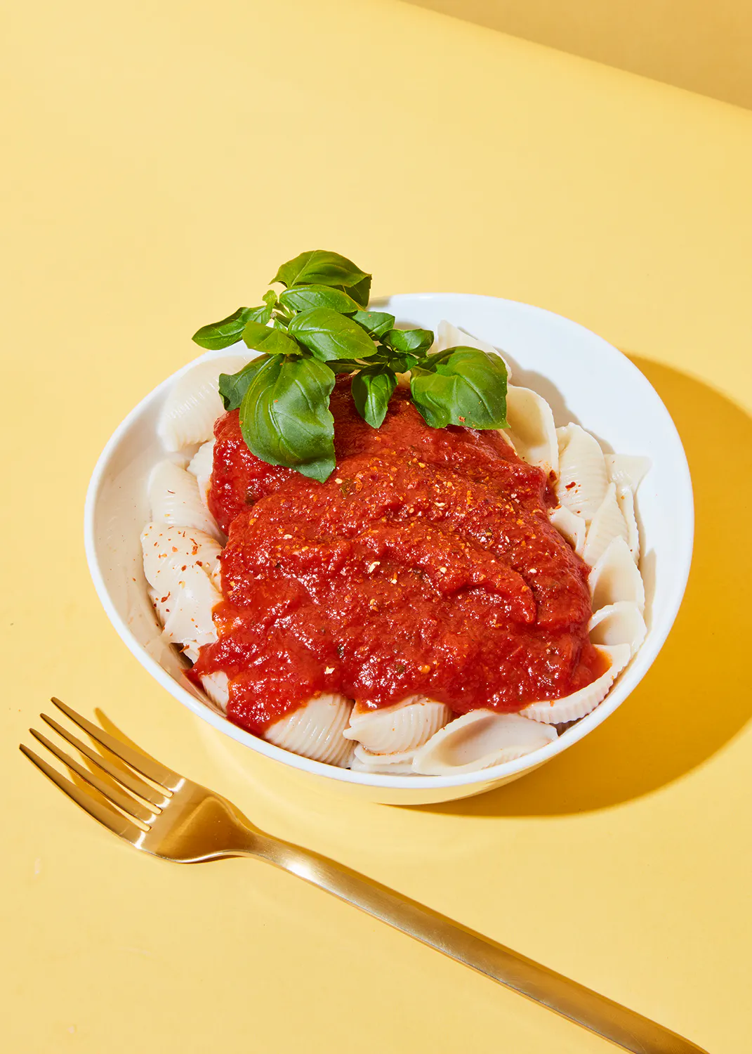 un bol de pâtes avec une sauce tomate et une fourchette