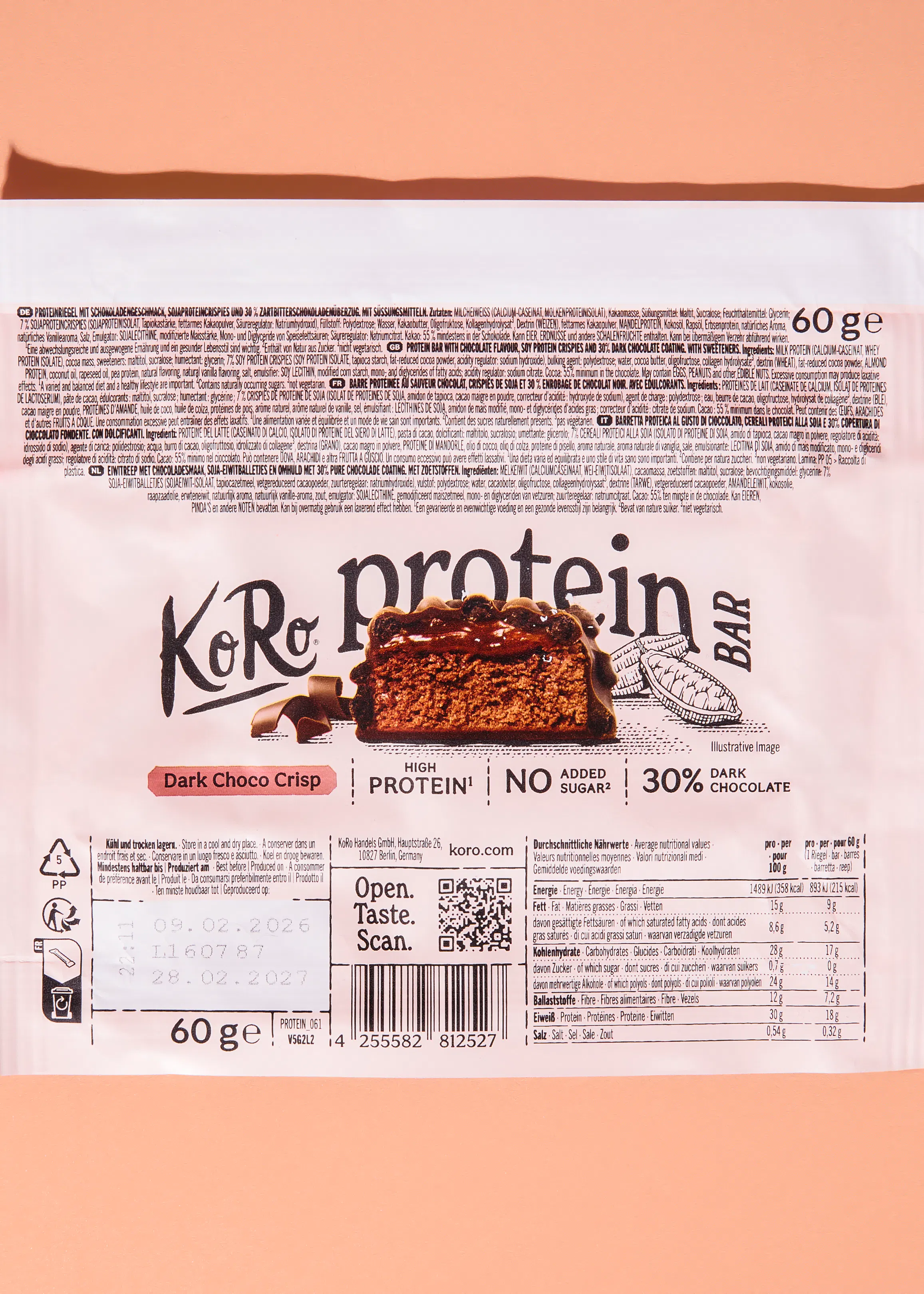 die verpackung eines koro proteinriegels 'dark choco crisp' zeigt einen anschnitt des riegels mit schokoladenüberzug und knuspriger textur, begleitet von den aufschriften 'high protein' und 'no added sugar'.