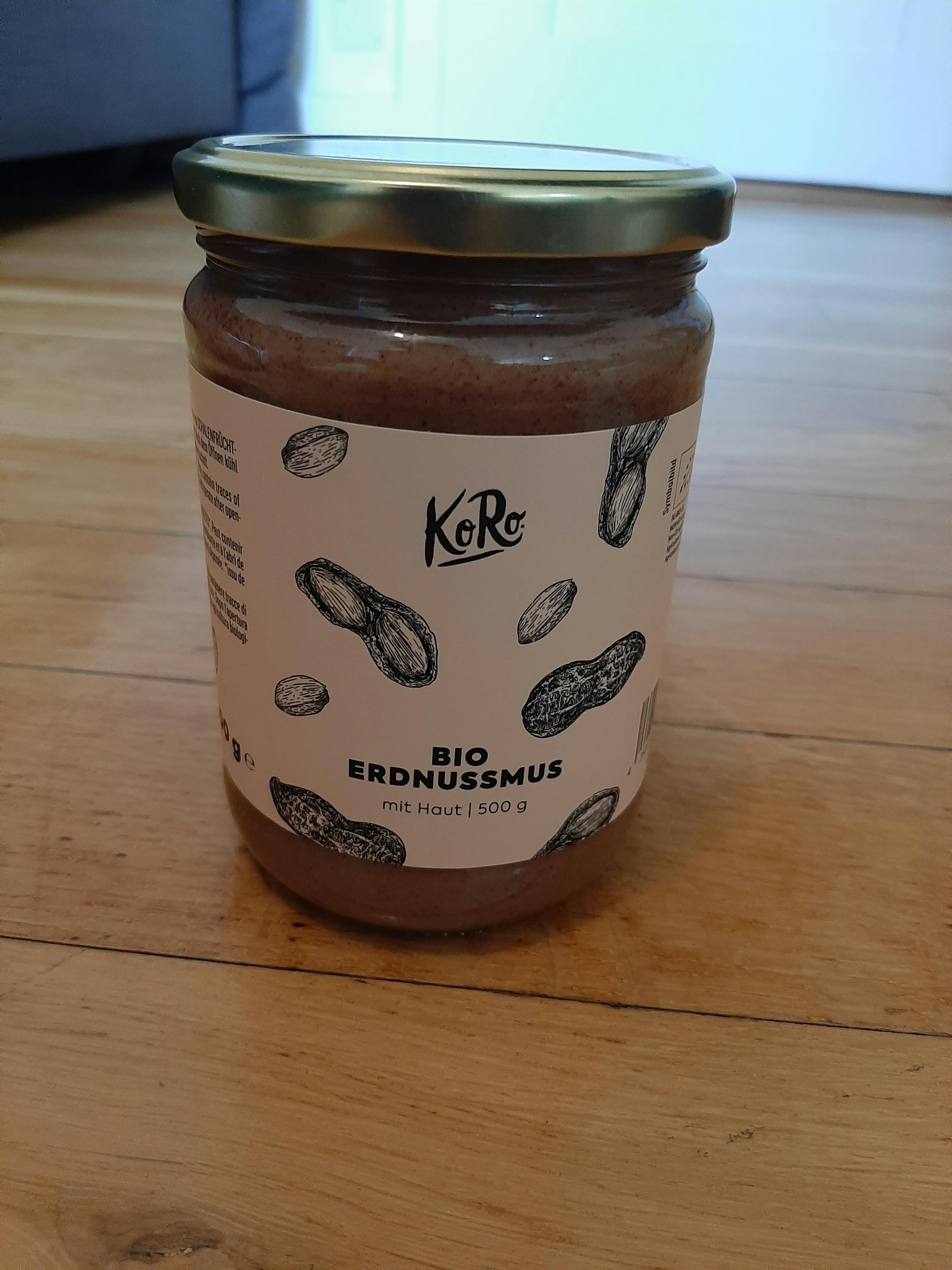 a jar of erdnussmus sits on a wooden table