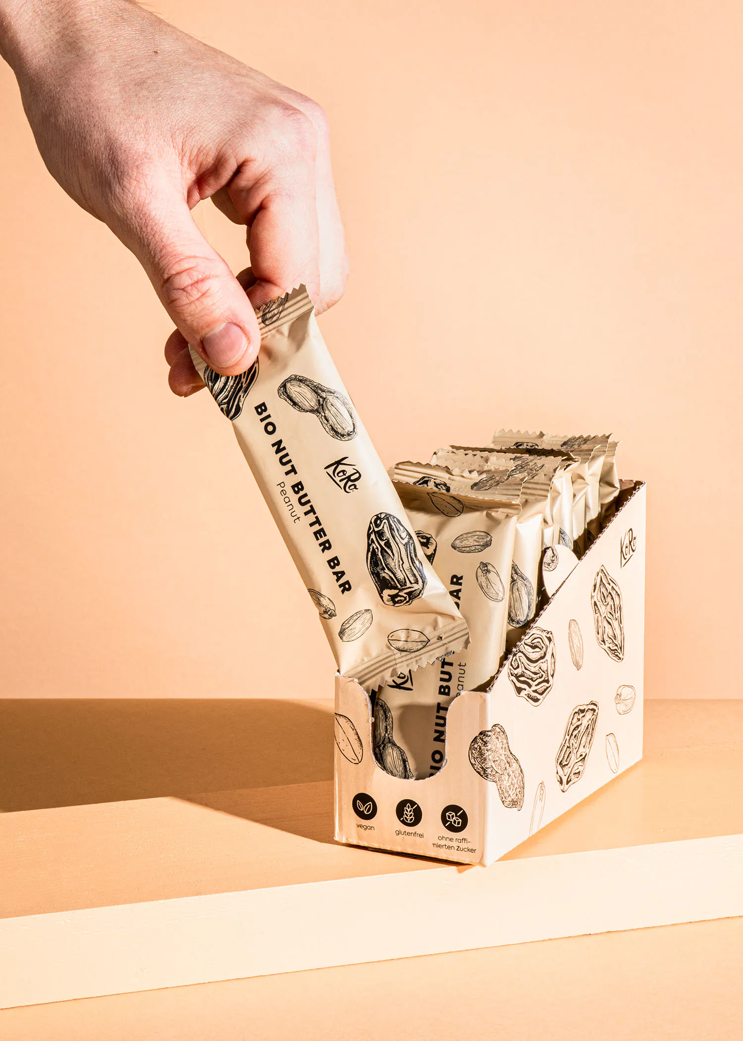une personne prend une barre de beurre de noix biologique de la boîte