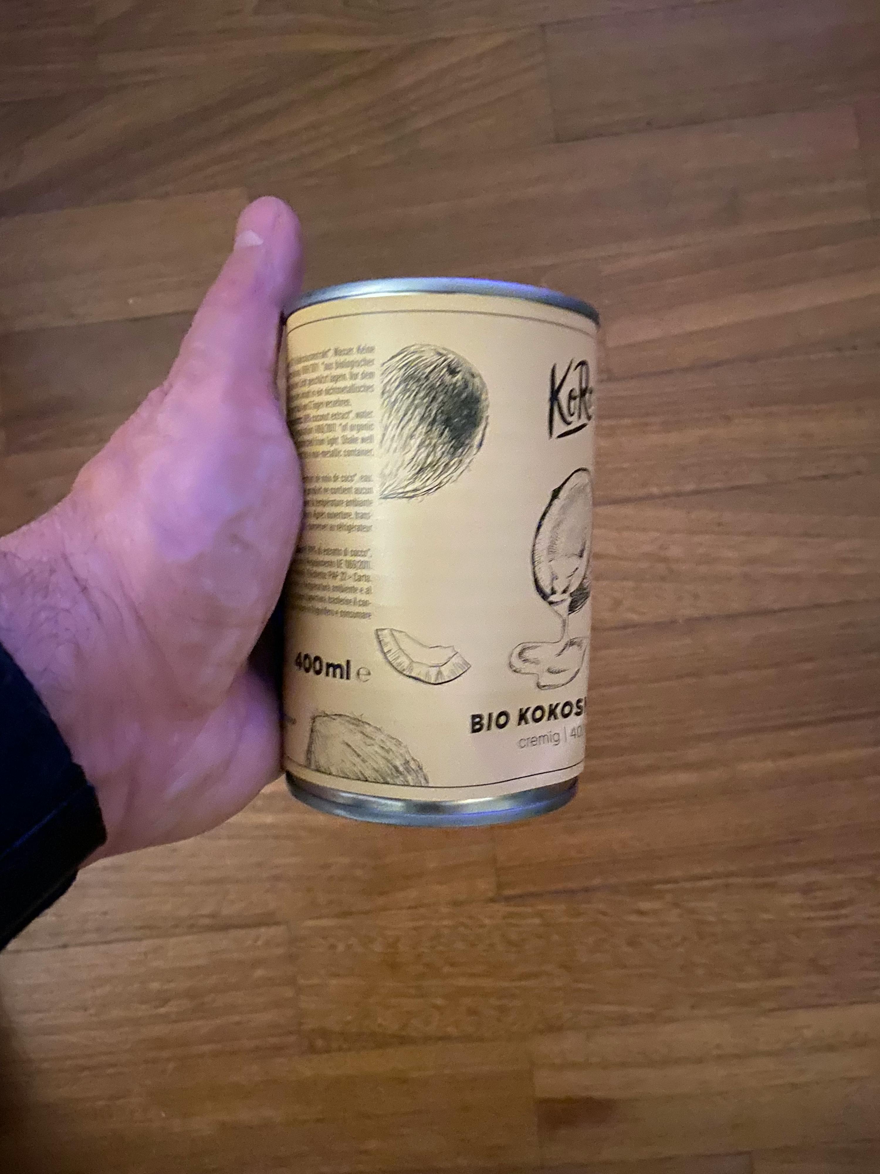 Eine Person hält eine Dose Bio-Kokos in der Hand