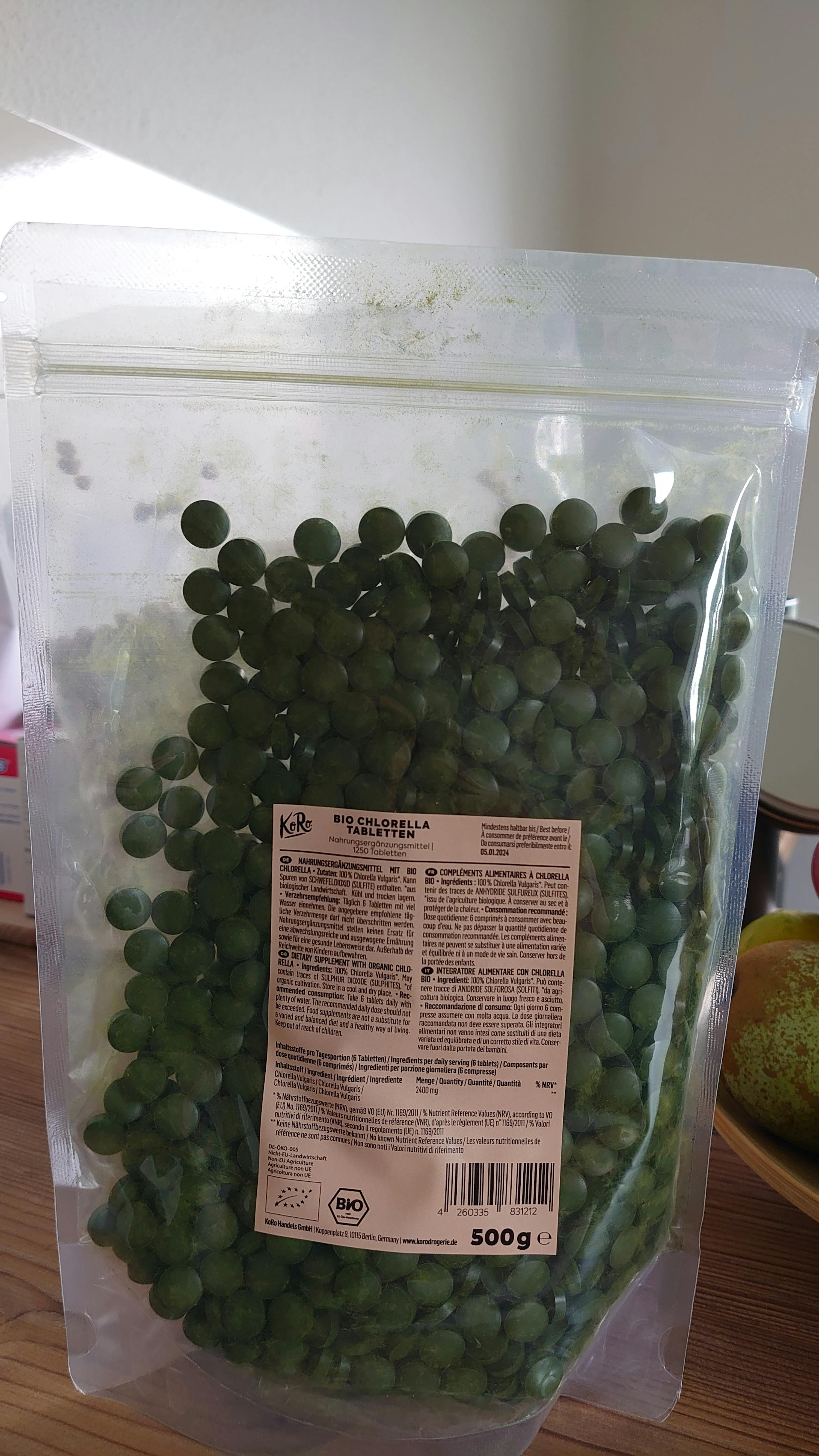 un sac de pois verts est posé sur une table en bois