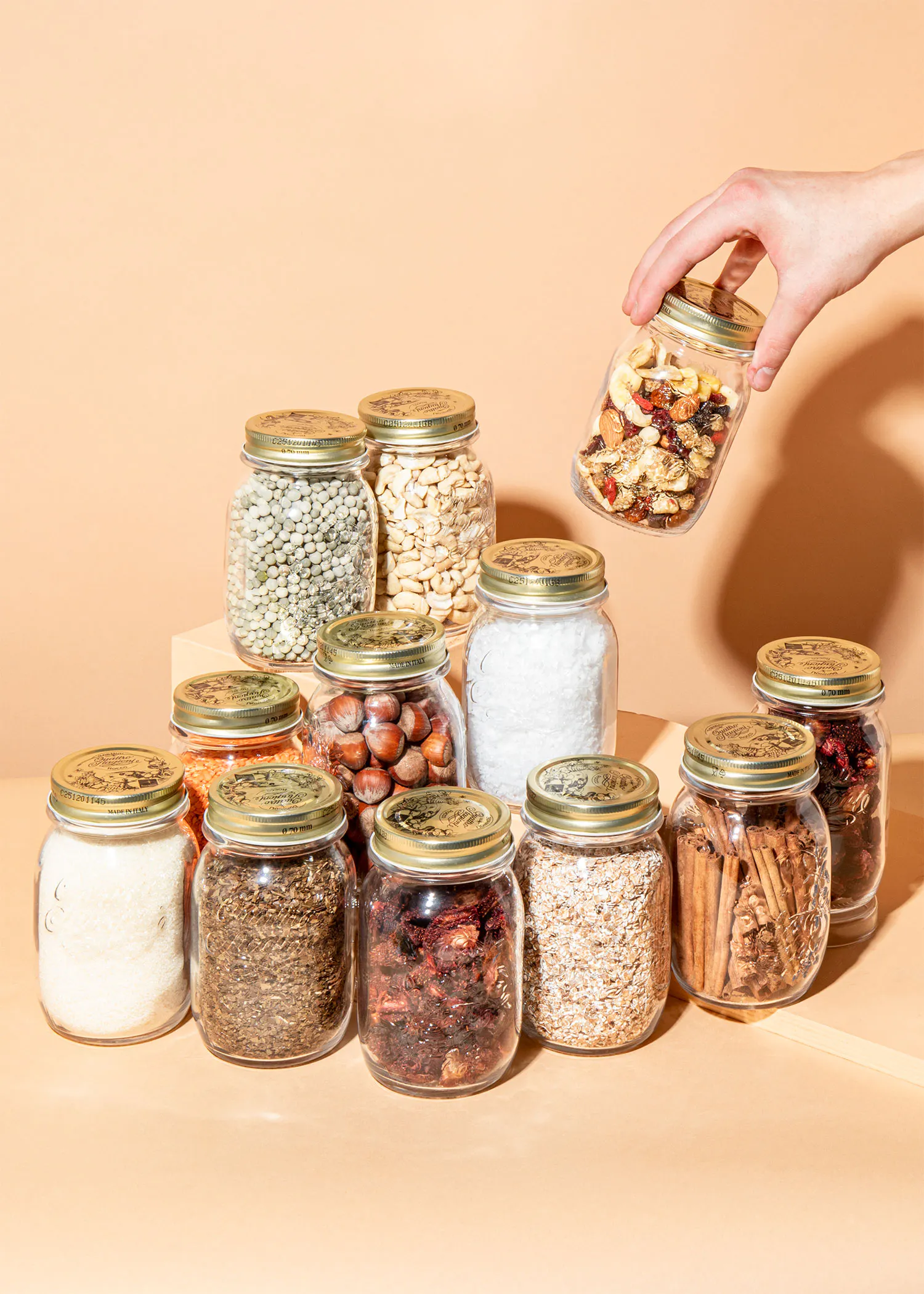 a hand is reaching into a jar with nuts in it