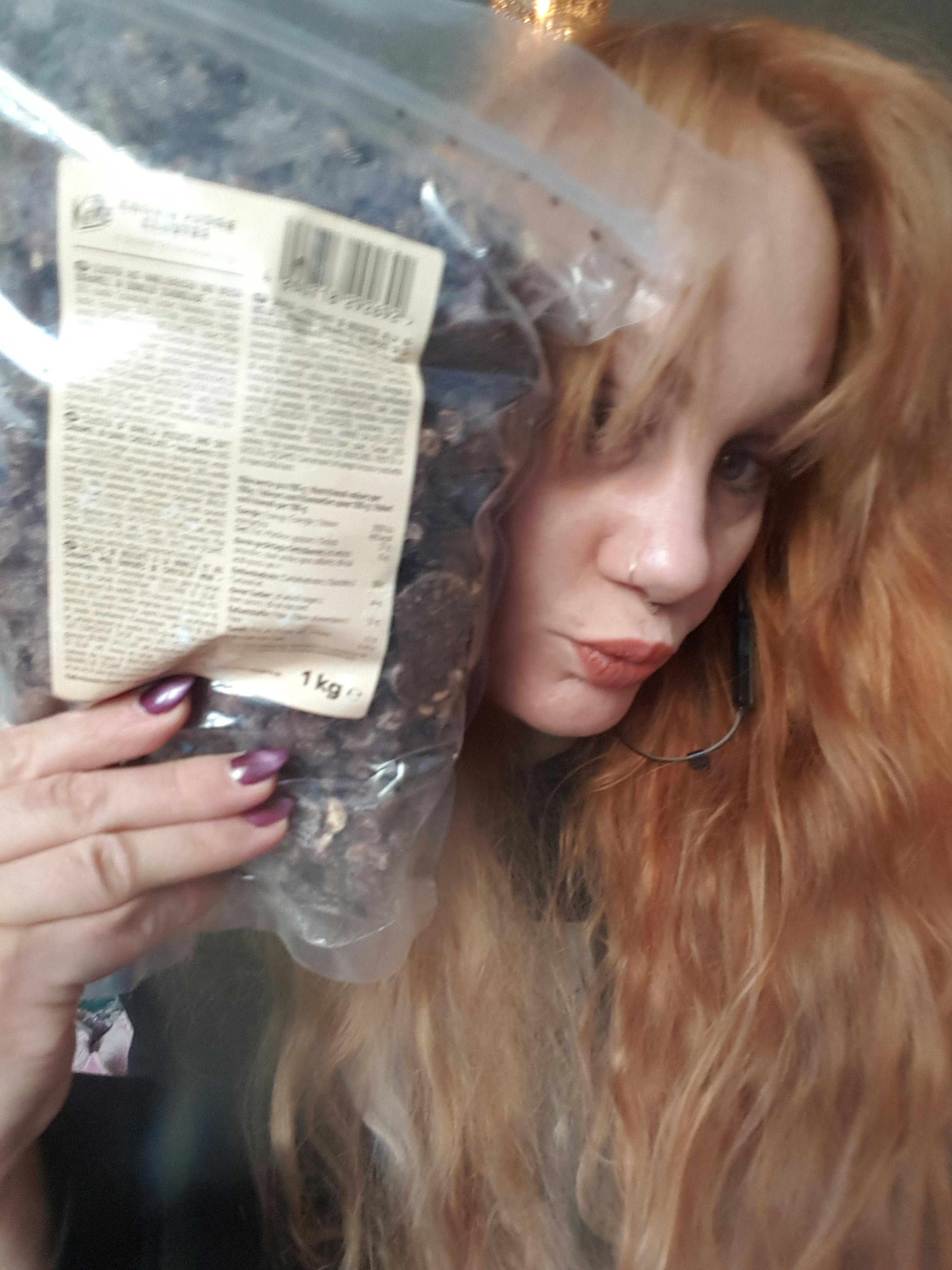 une femme allongée sur le dos tenant un sac de 1 kg de raisins secs