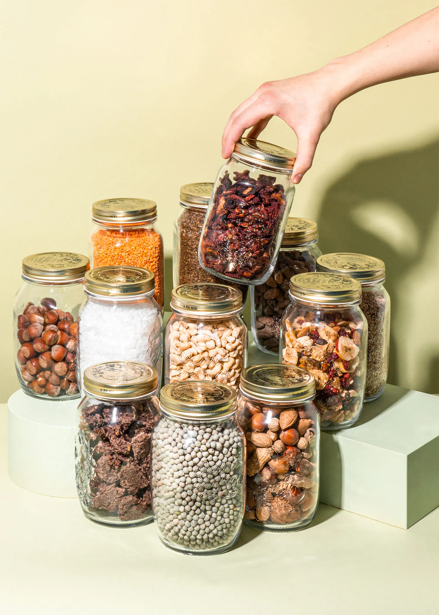 une personne remplit un bocal en verre avec des raisins secs