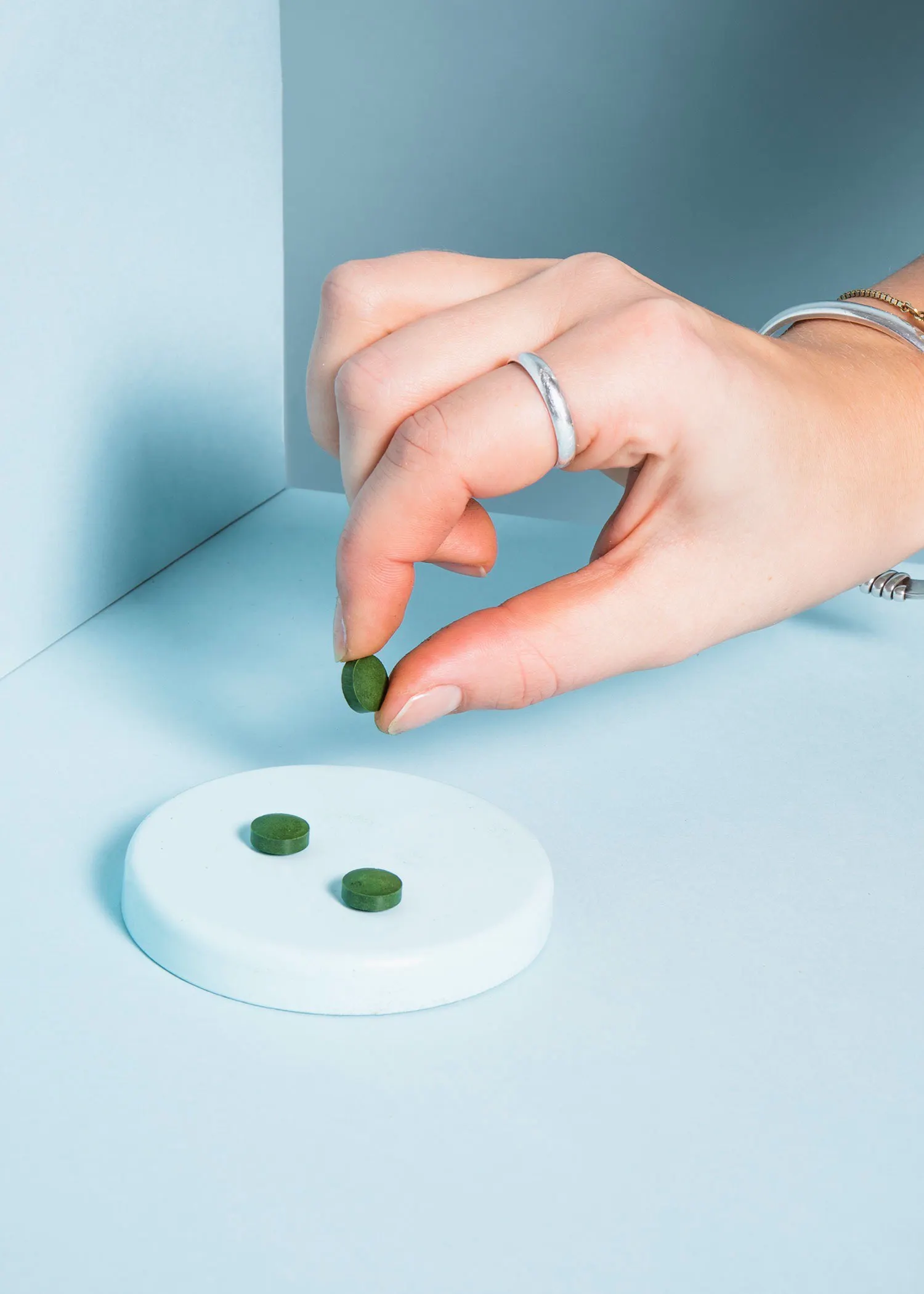 une personne prend une pilule verte à l' index