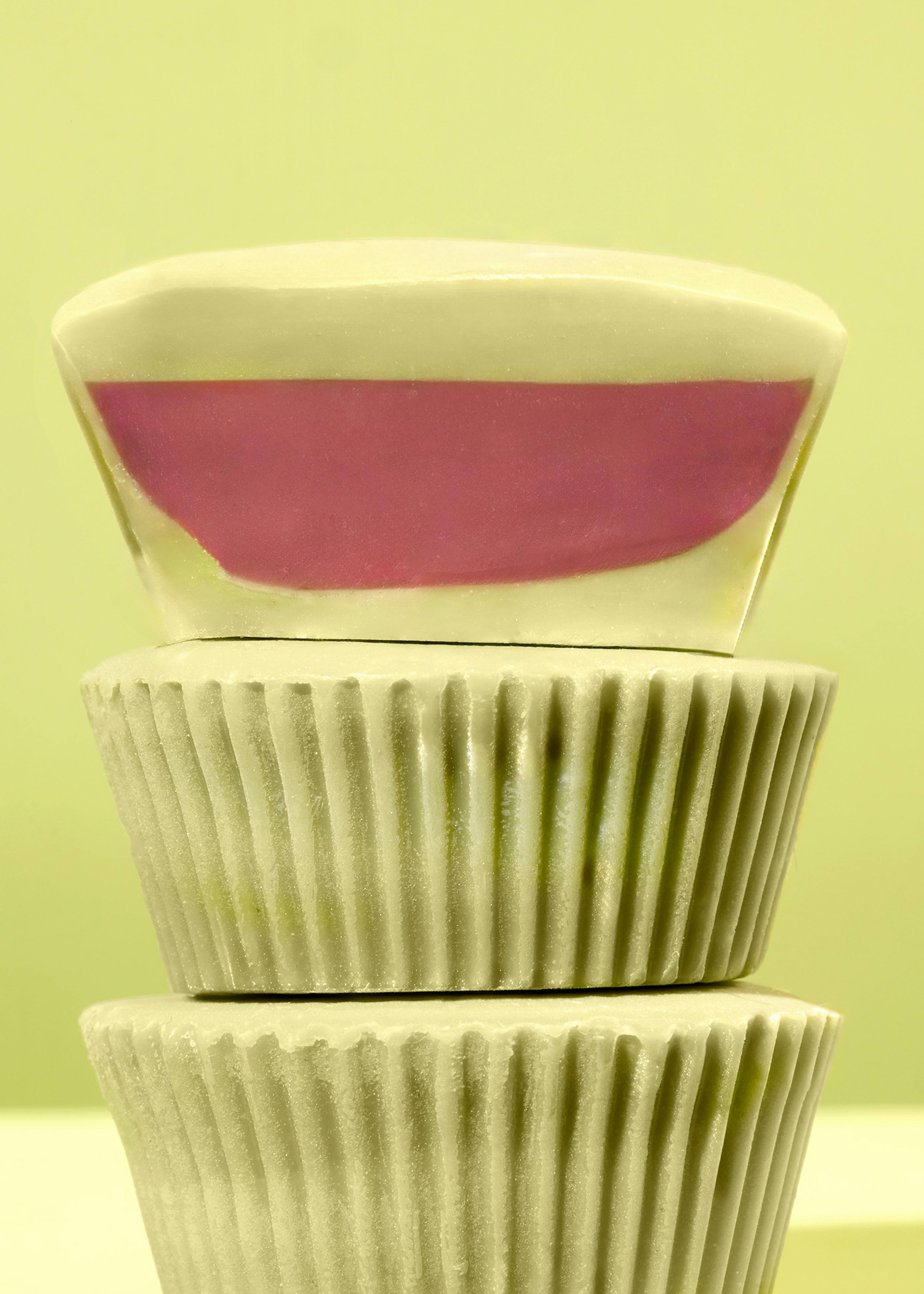 trois cupcakes blancs empilés les uns sur les autres avec un intérieur rose