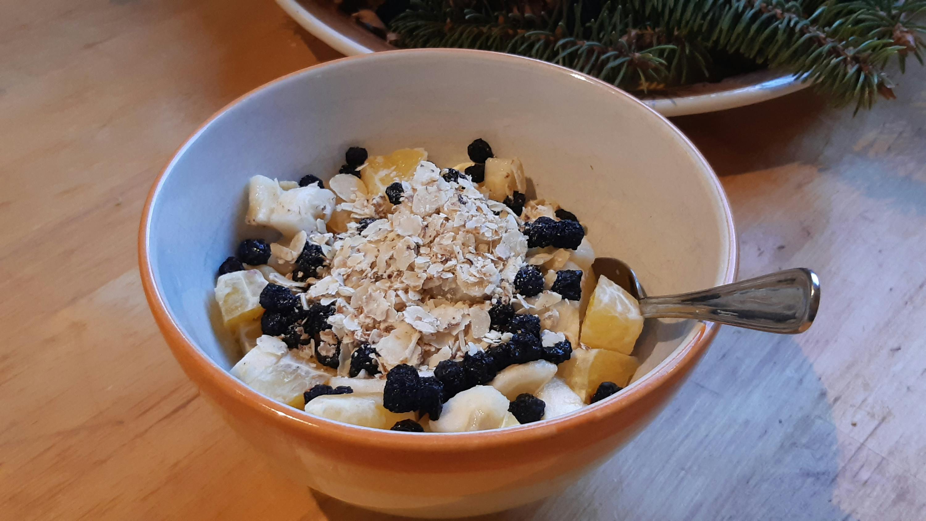 a bowl of fruit and oatmeal with a spoon