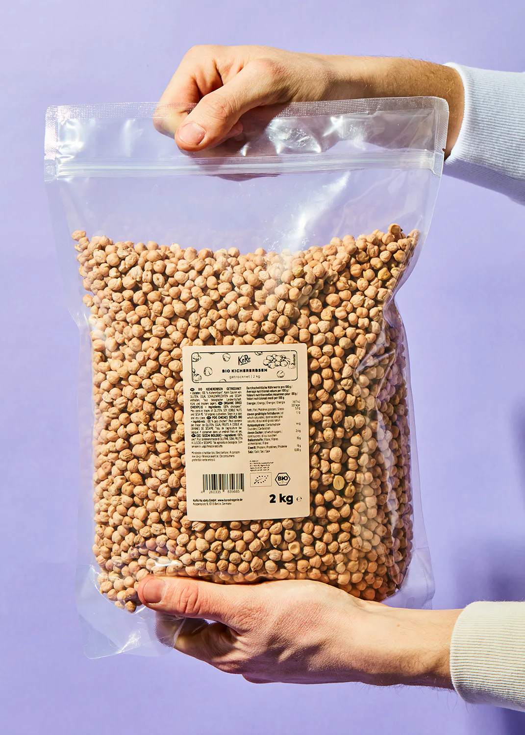 a person is holding a bag of chickpeas that is 2 kg