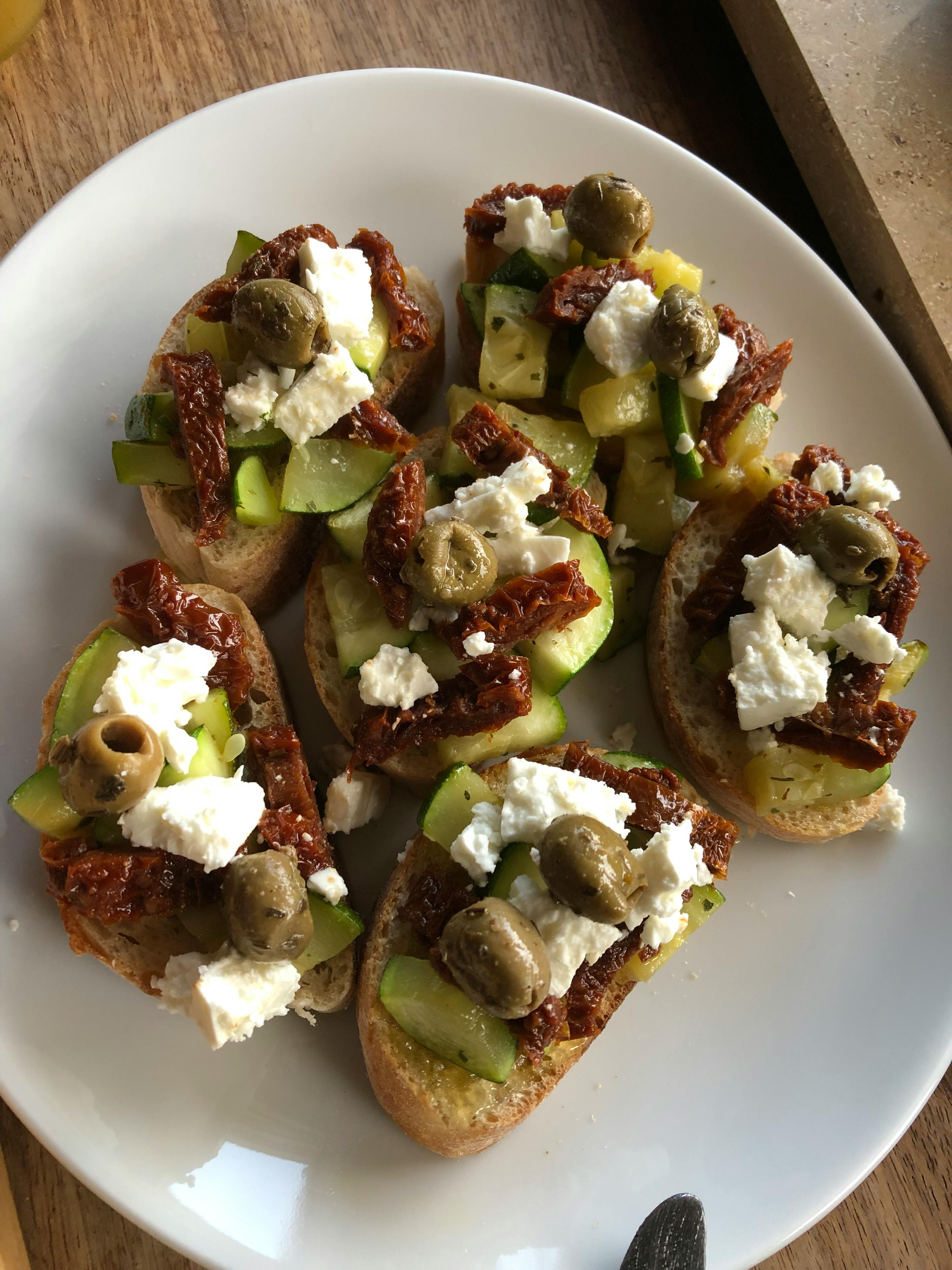 a white plate topped with a variety of vegetables and cheese