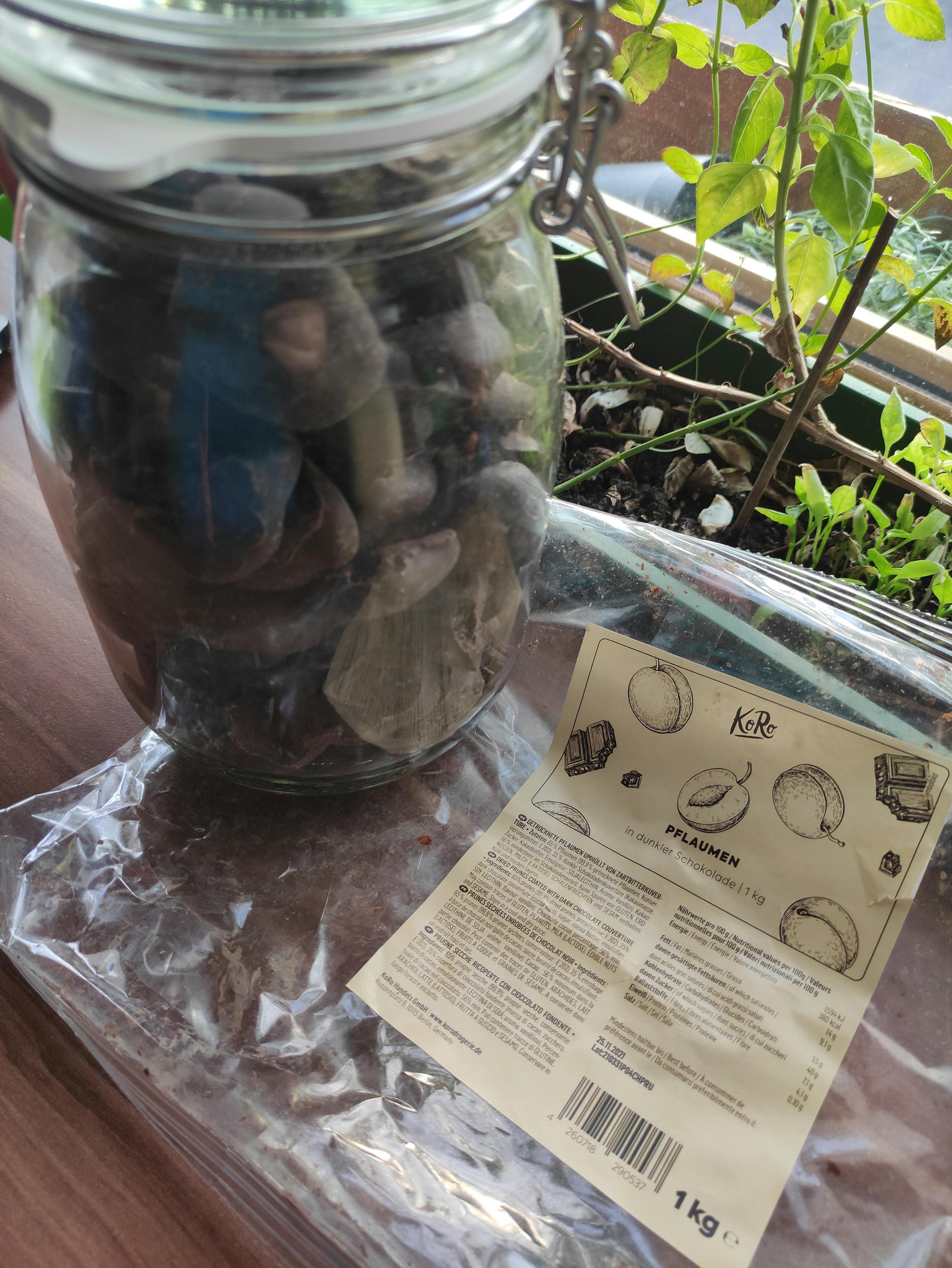 un bocal en verre rempli de pierres à côté d' un sac en plastique de 1 kg