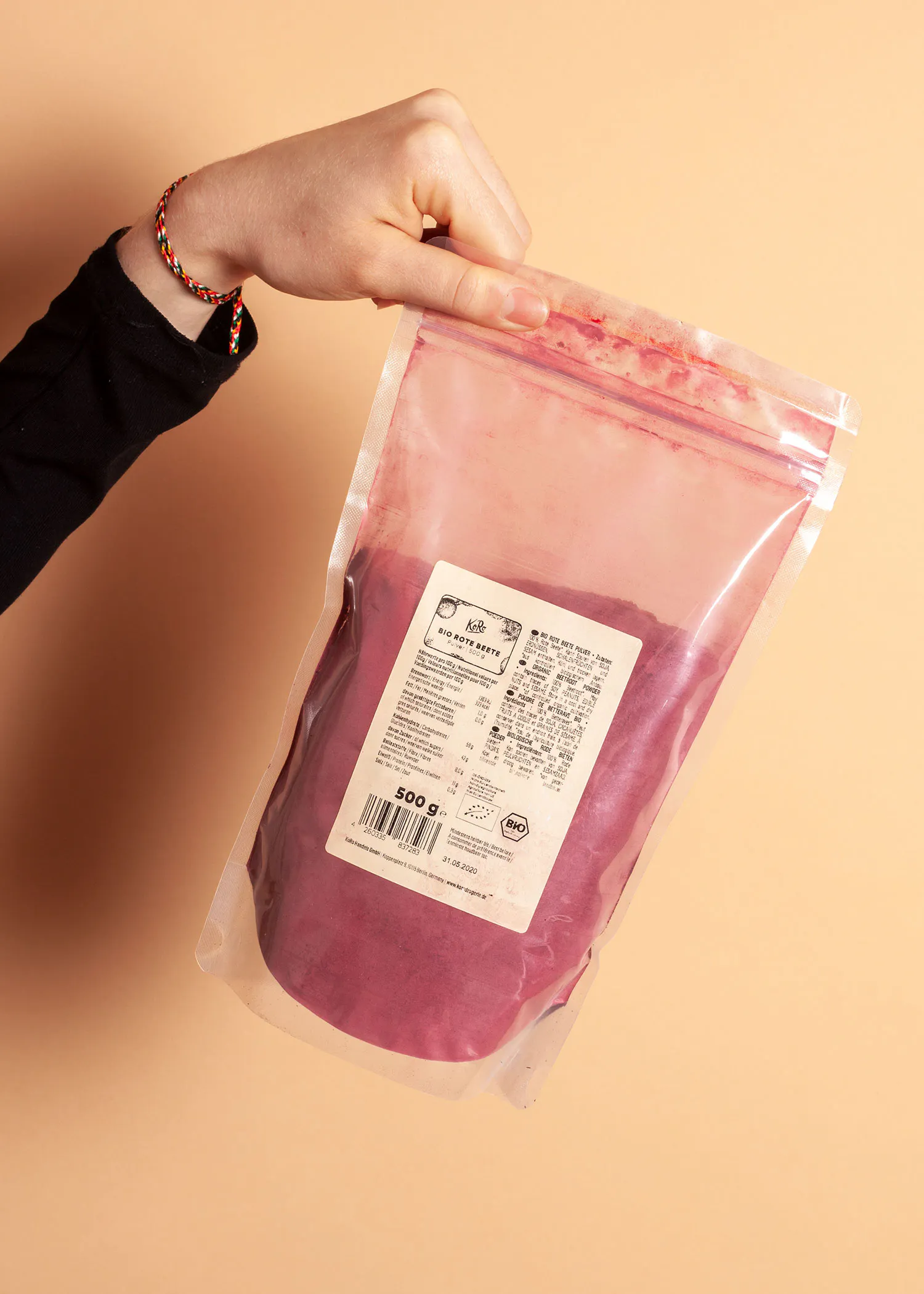 une personne tient un sac en plastique rempli de poudre rose