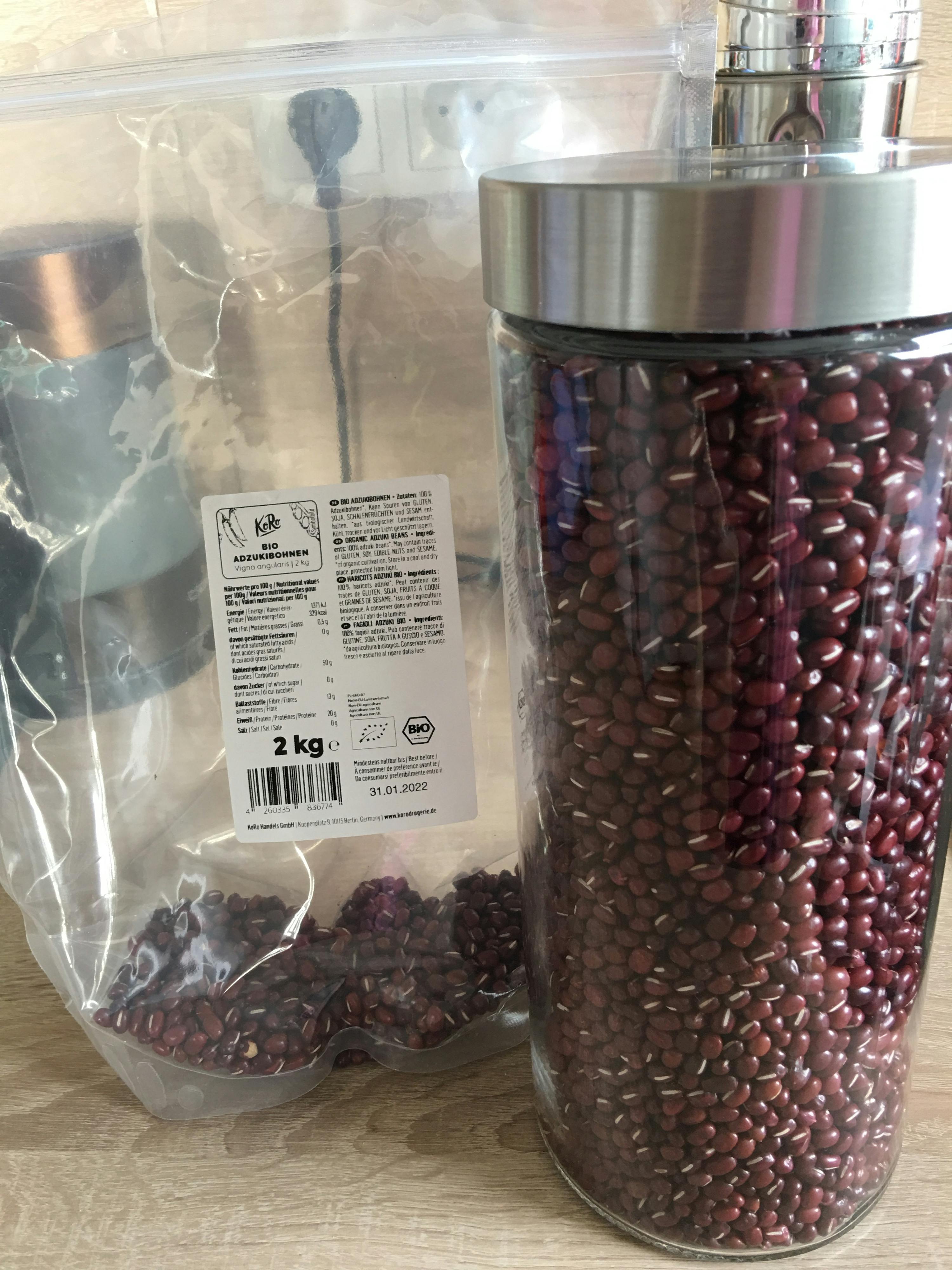 ein Glasgefäß voller roten Bohnen neben einem Plastikbeutel