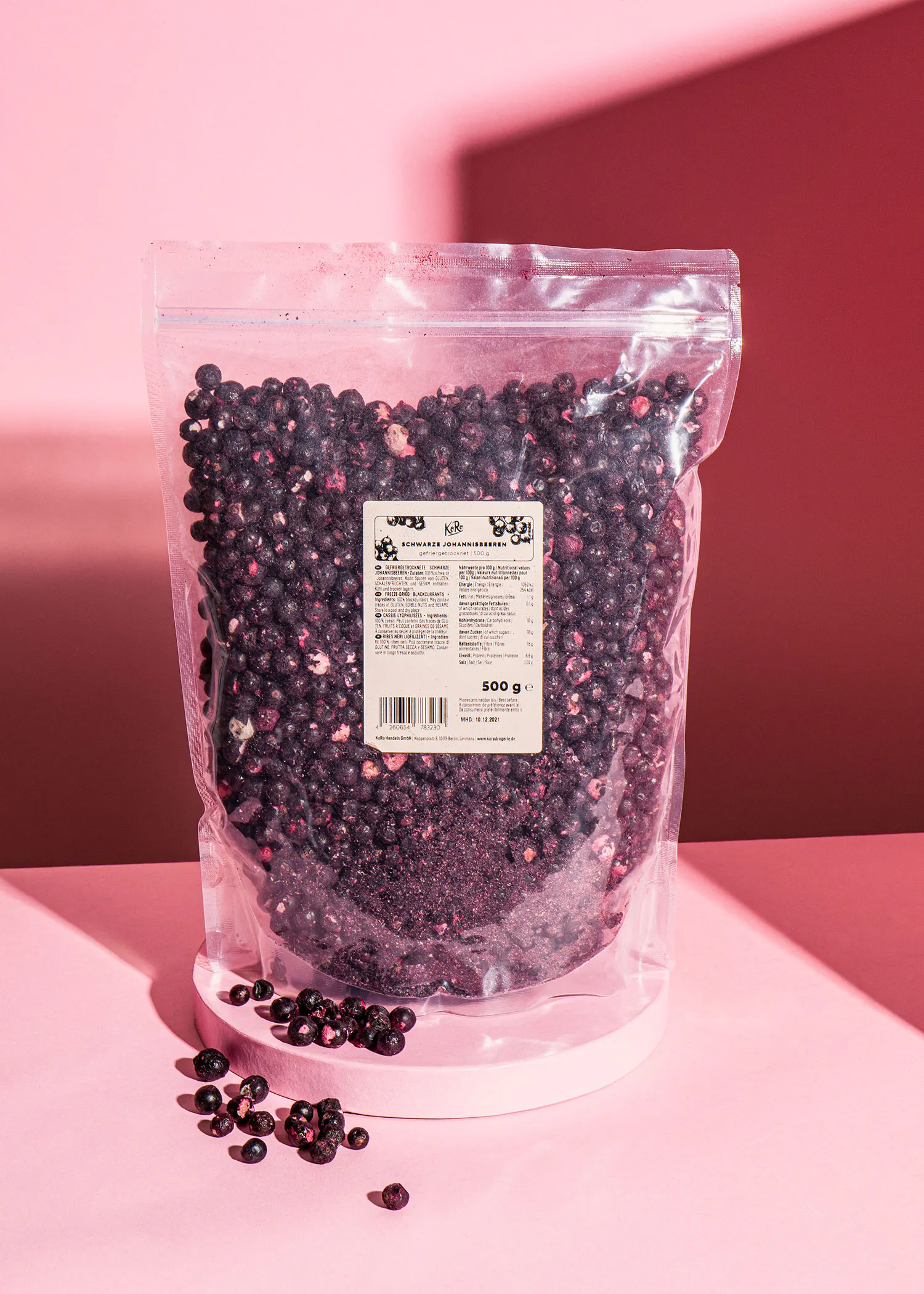 a bag of blueberries is on a pink surface