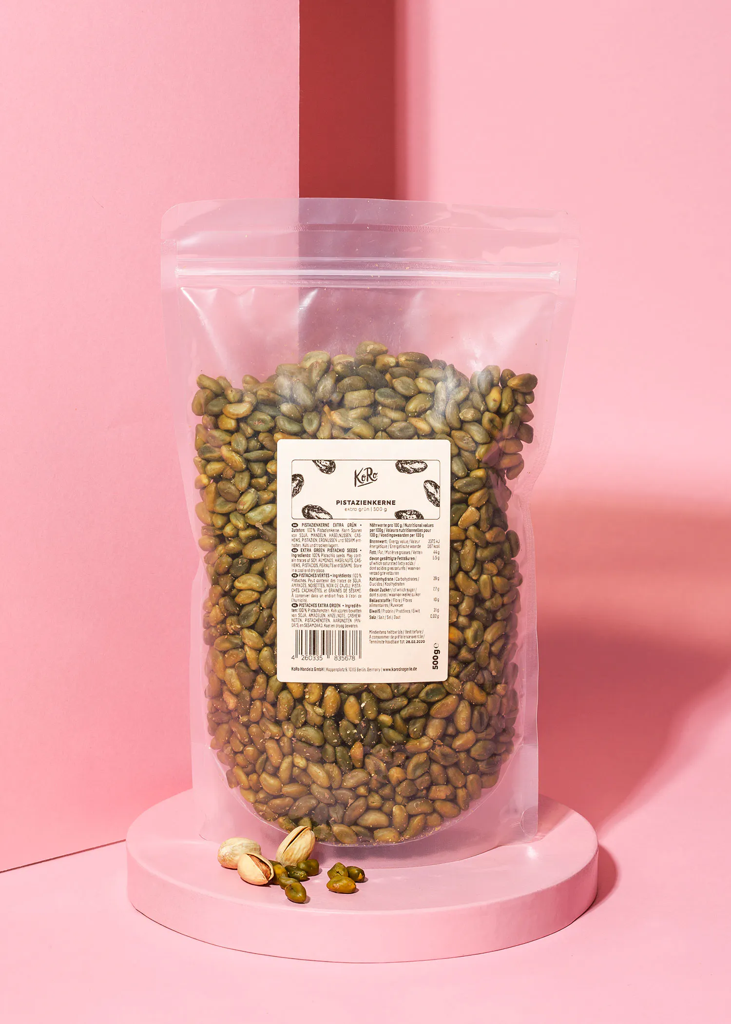 un sac de pistaches est assis sur une table rose