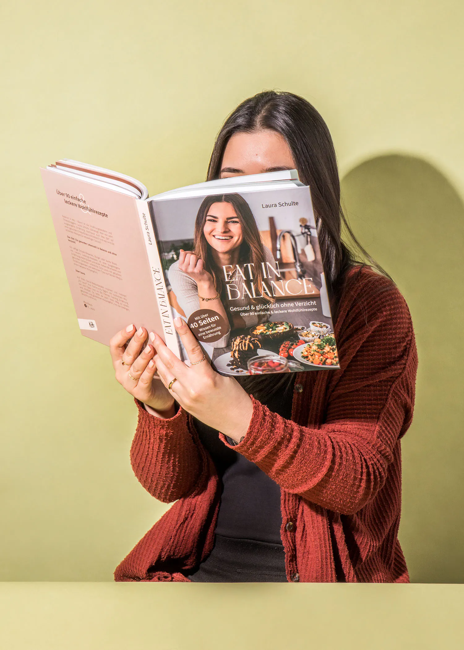 a woman is reading a book titled eat in balance