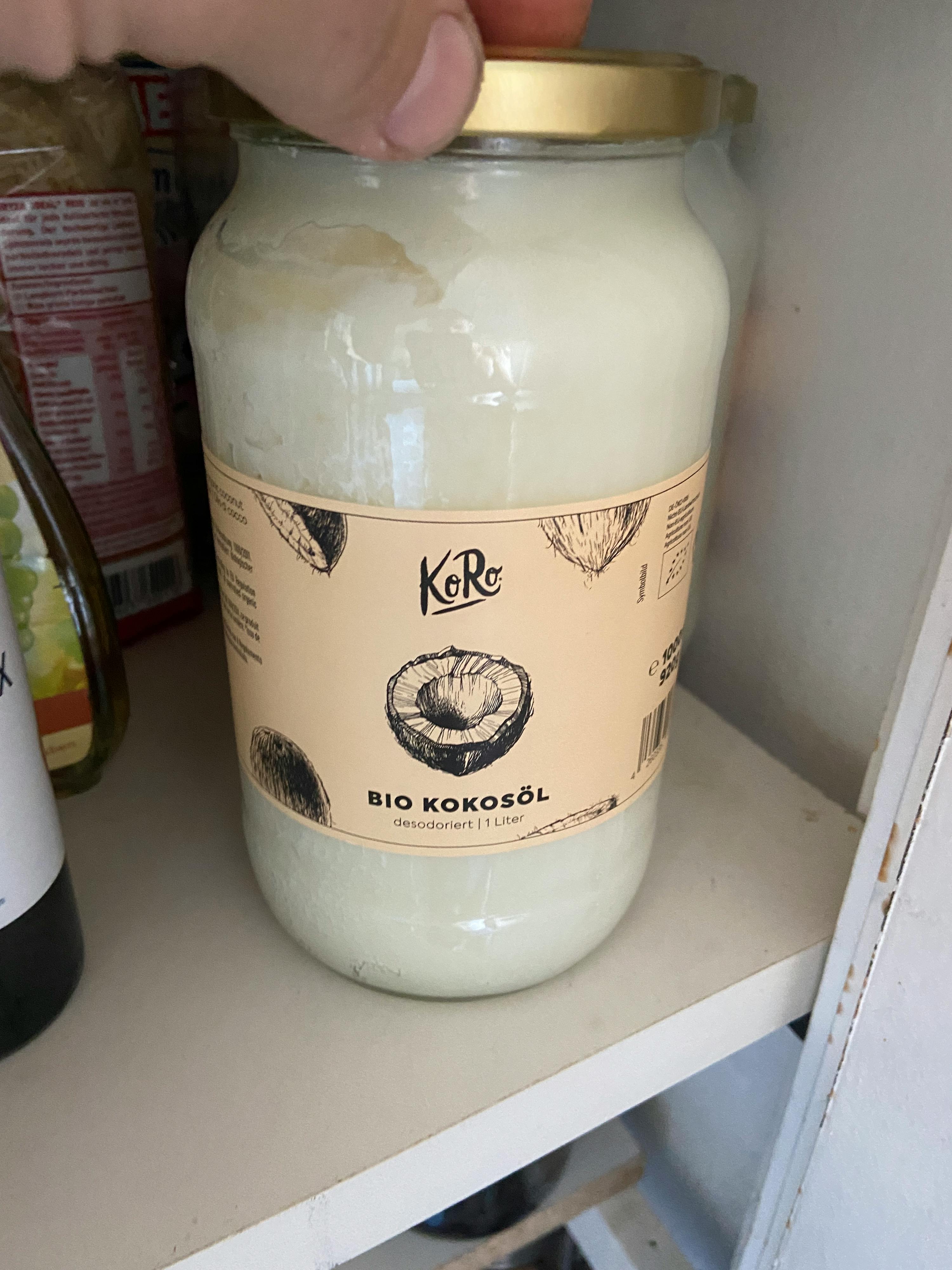 una persona tiene in mano un barattolo di olio di cocco