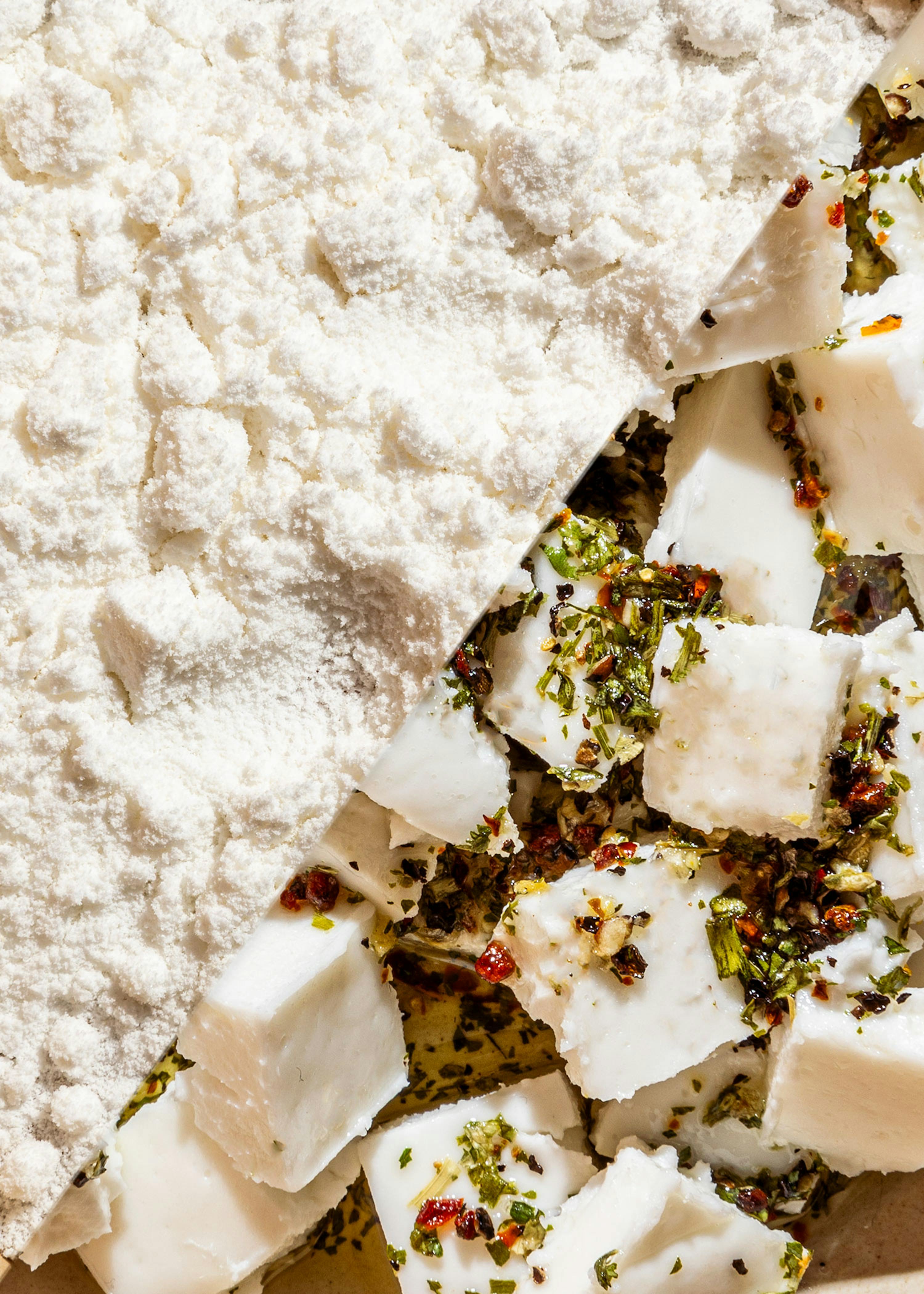 ein Stück Käse liegt auf einem Tisch neben einem Haufenmehl