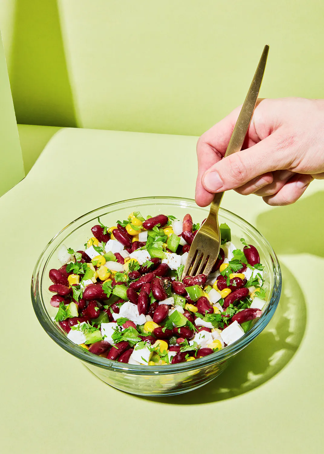 une personne mange une salade de haricots avec une fourchette