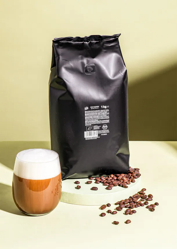 a bag of coffee beans next to a cup of coffee