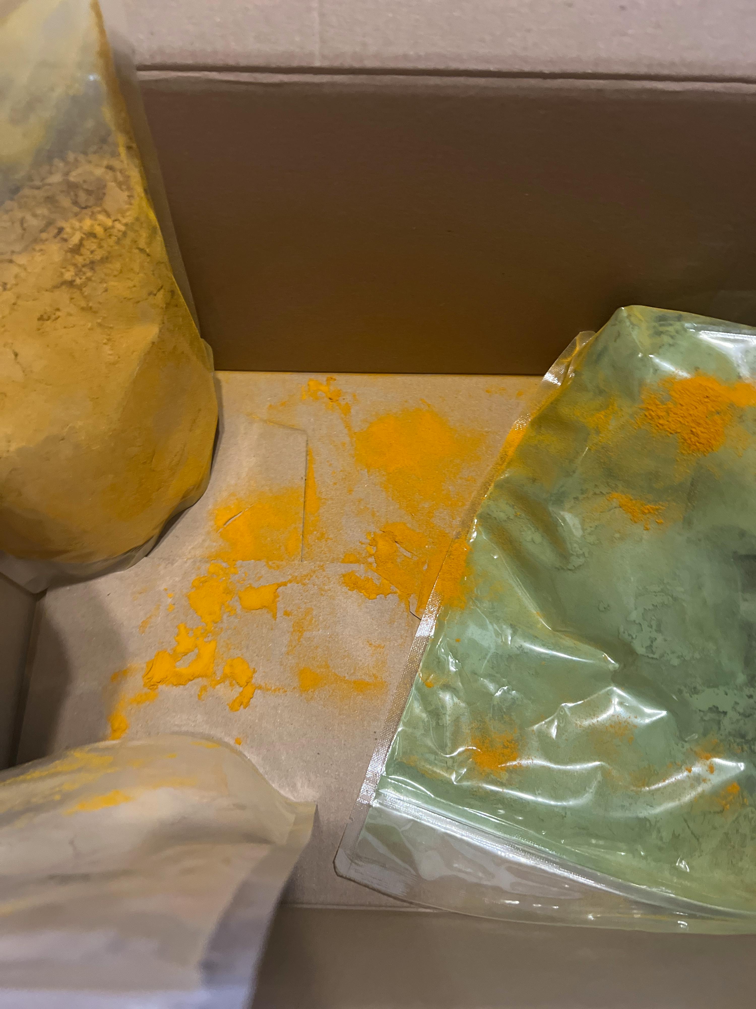 eine Schachtel mit grünem und gelbem Pulver steht neben einer Schachtel mit weißem Pulver