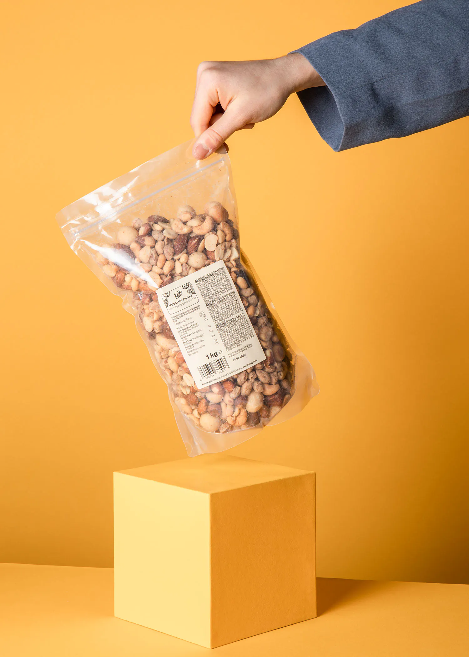 une personne tient un sac de noix dessus d' un bloc jaune