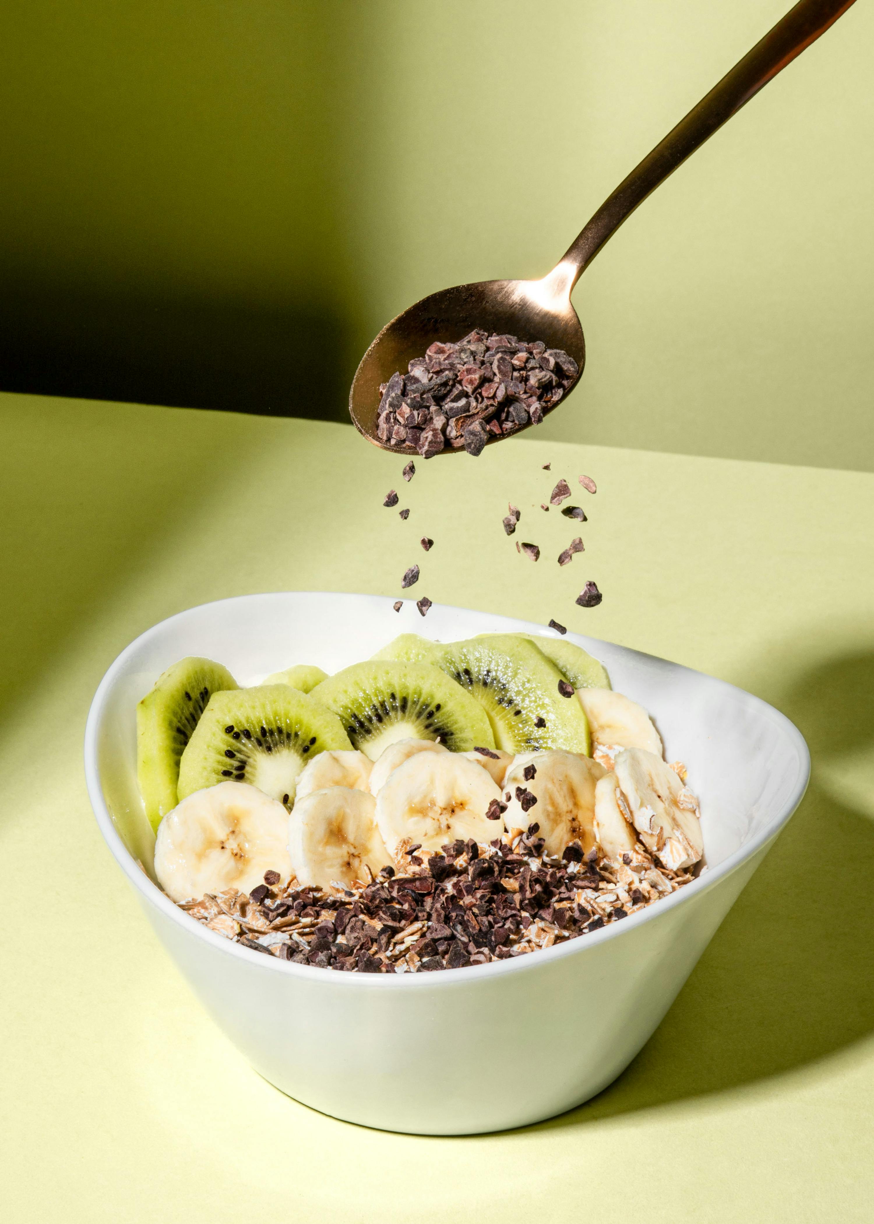 un bol de céréales avec des tranches de banane et de kiwis