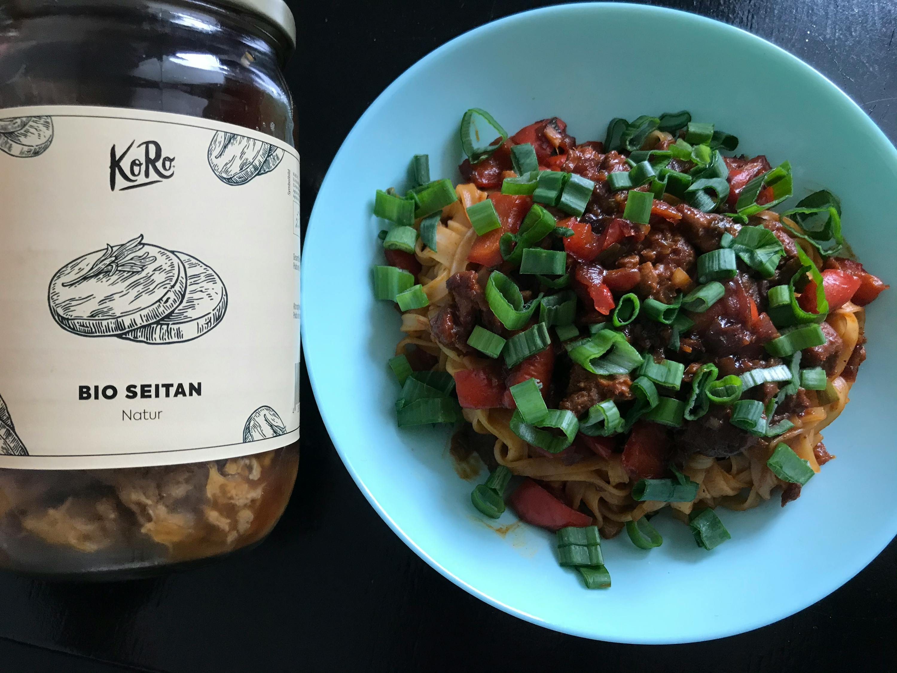 un barattolo di bio seitan si trova accanto a un piatto di pasta