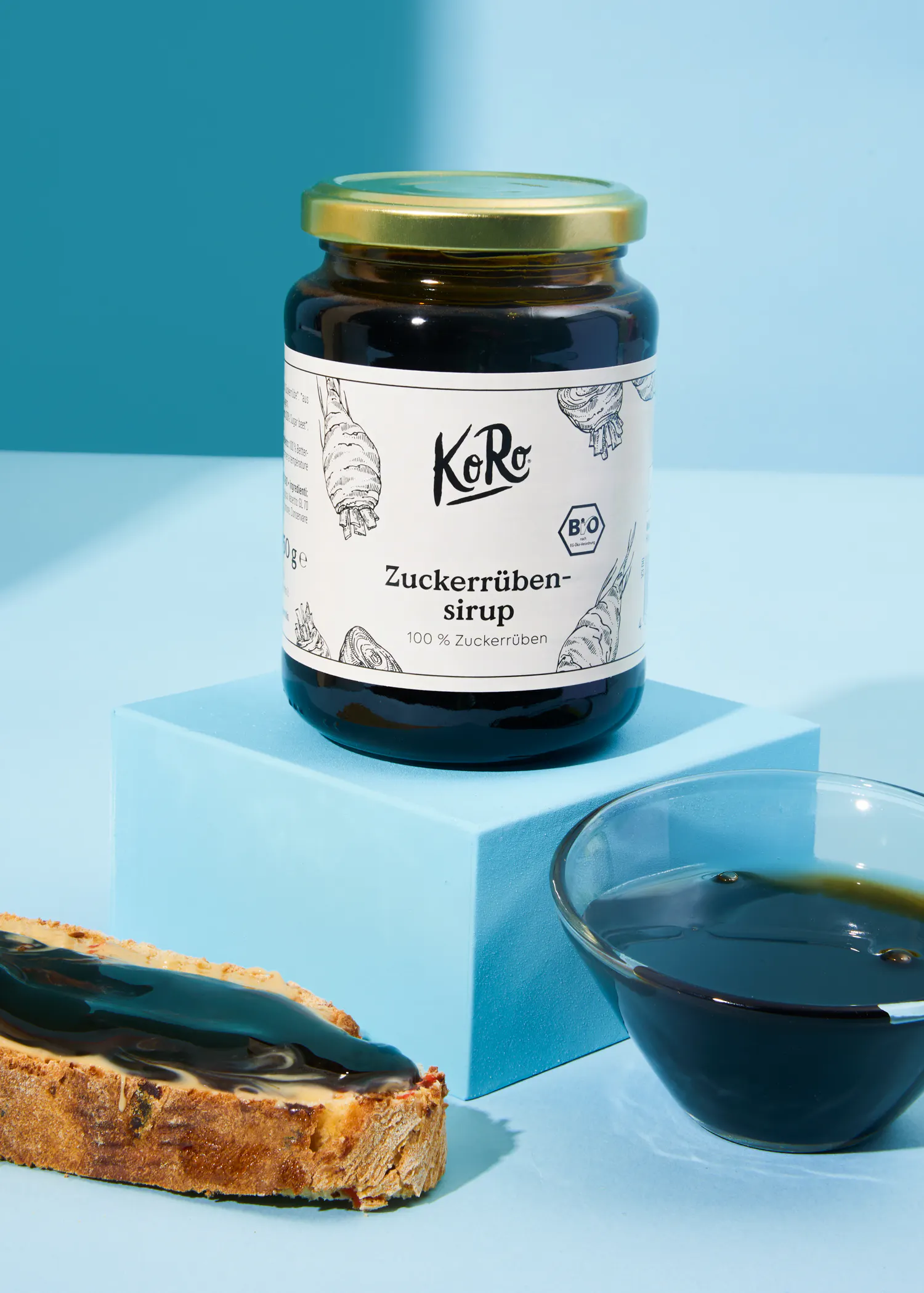 a jar of zuckerrüben-sirup sits next to a slice of bread