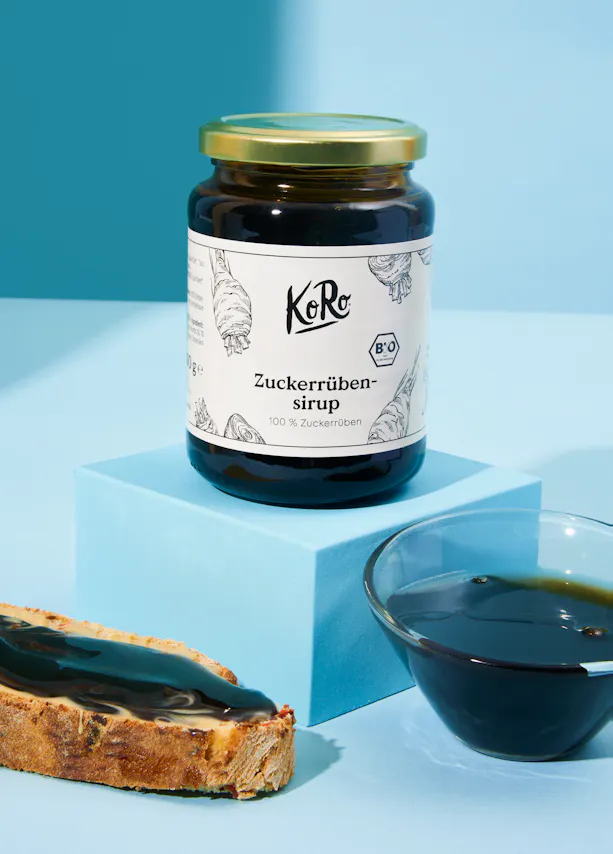 un bocal de sirop zuckerrüben-sirup avec une tranche de pain à côté