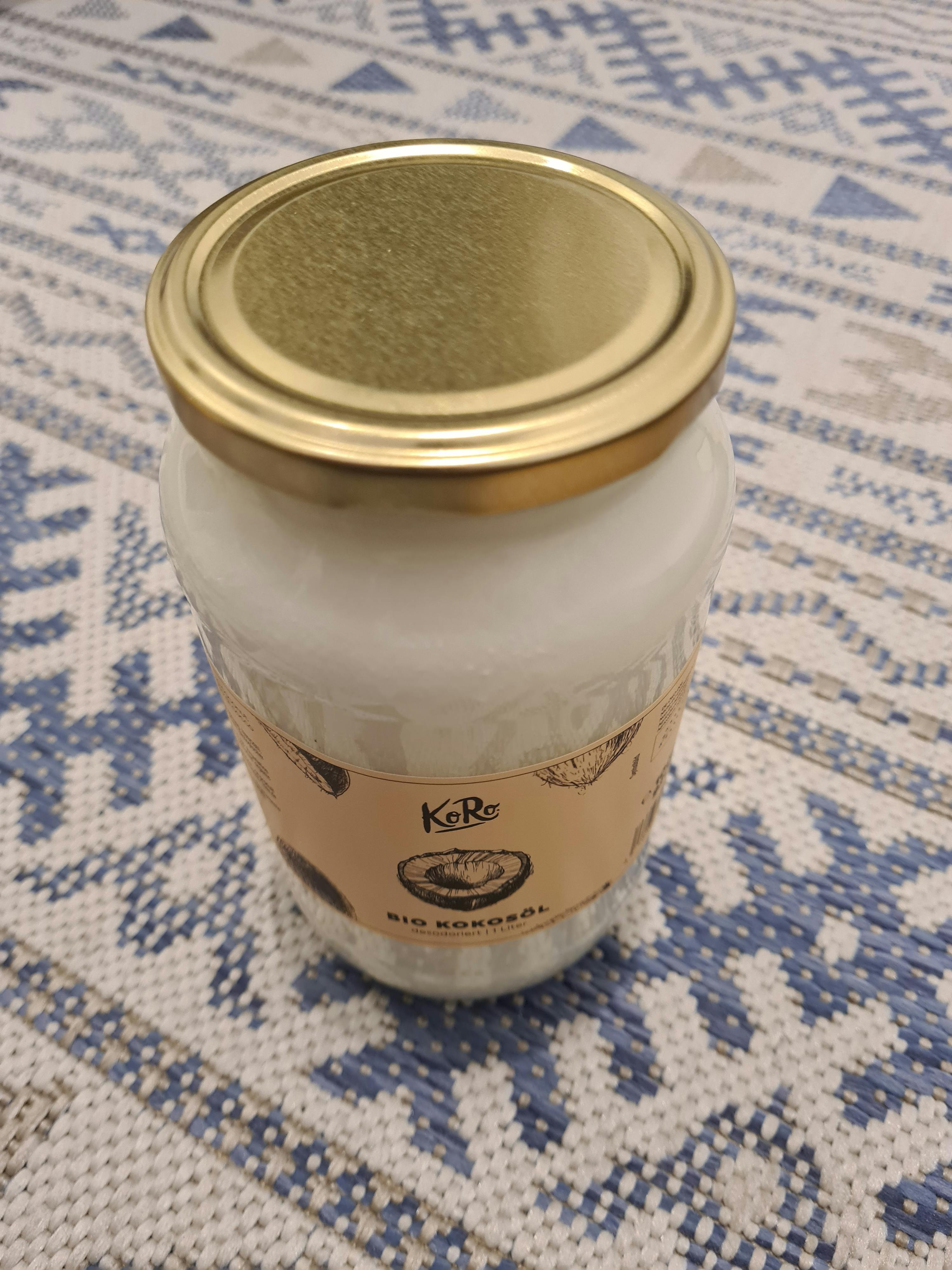 un barattolo di olio di cocco è seduto su un tappeto blu e bianco