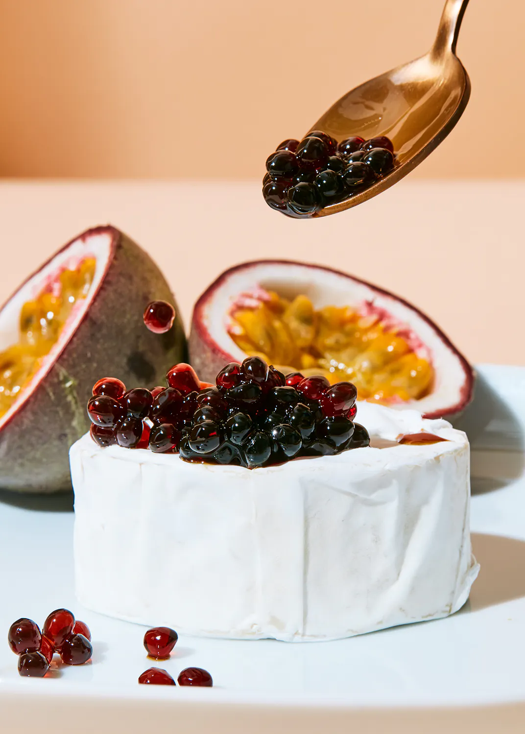 un trozo de queso con granadas y maracuyá encima