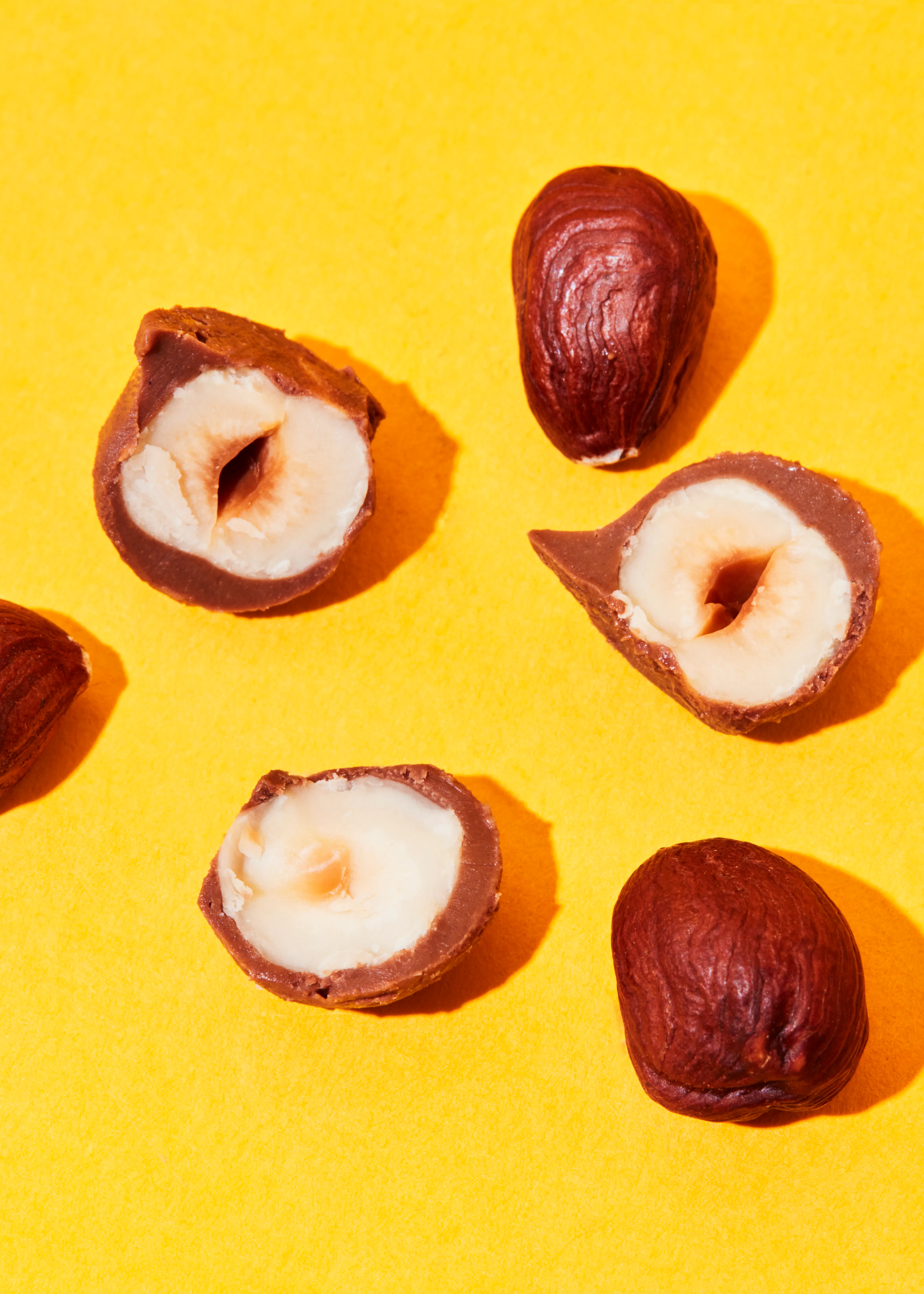 eine Haselnüsse in Schokolade auf einem gelben Hintergrund
