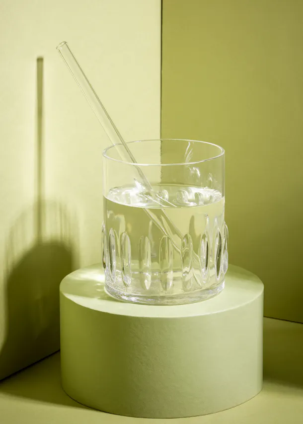 a glass of water with a straw in it