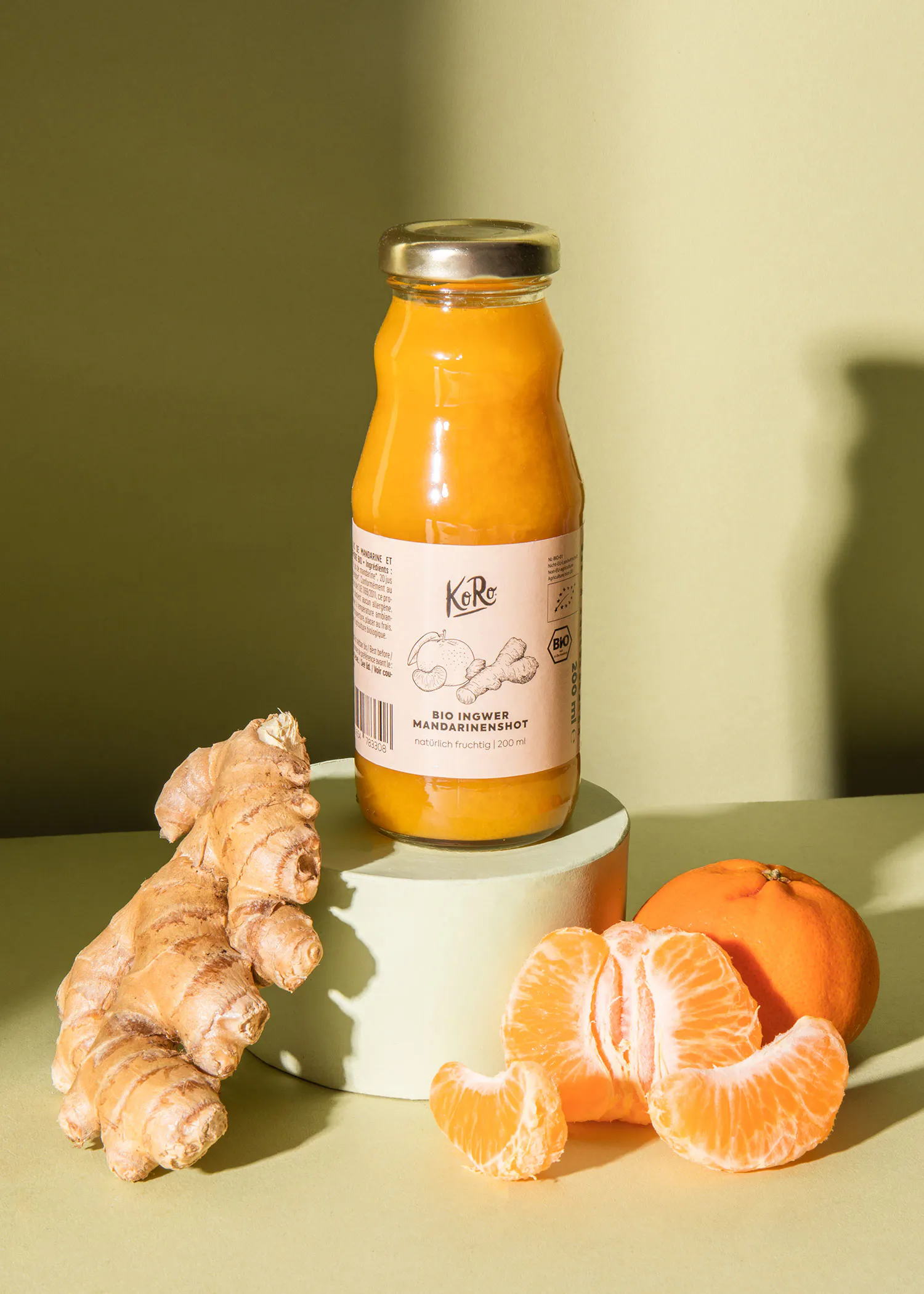 a jar of bio ginger mandarinefruit sits next to oranges and ginger