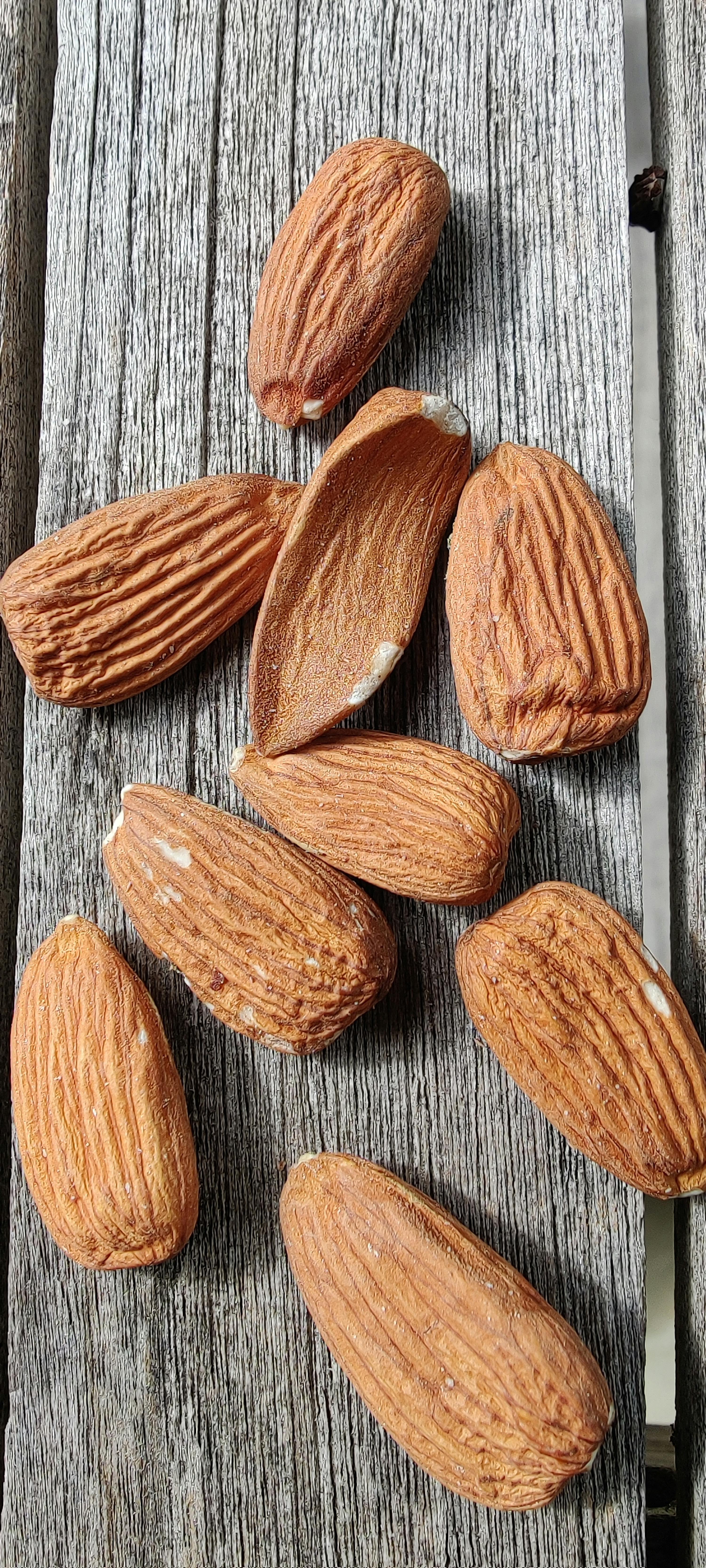 a bunch of almonds are sitting on a wooden surface