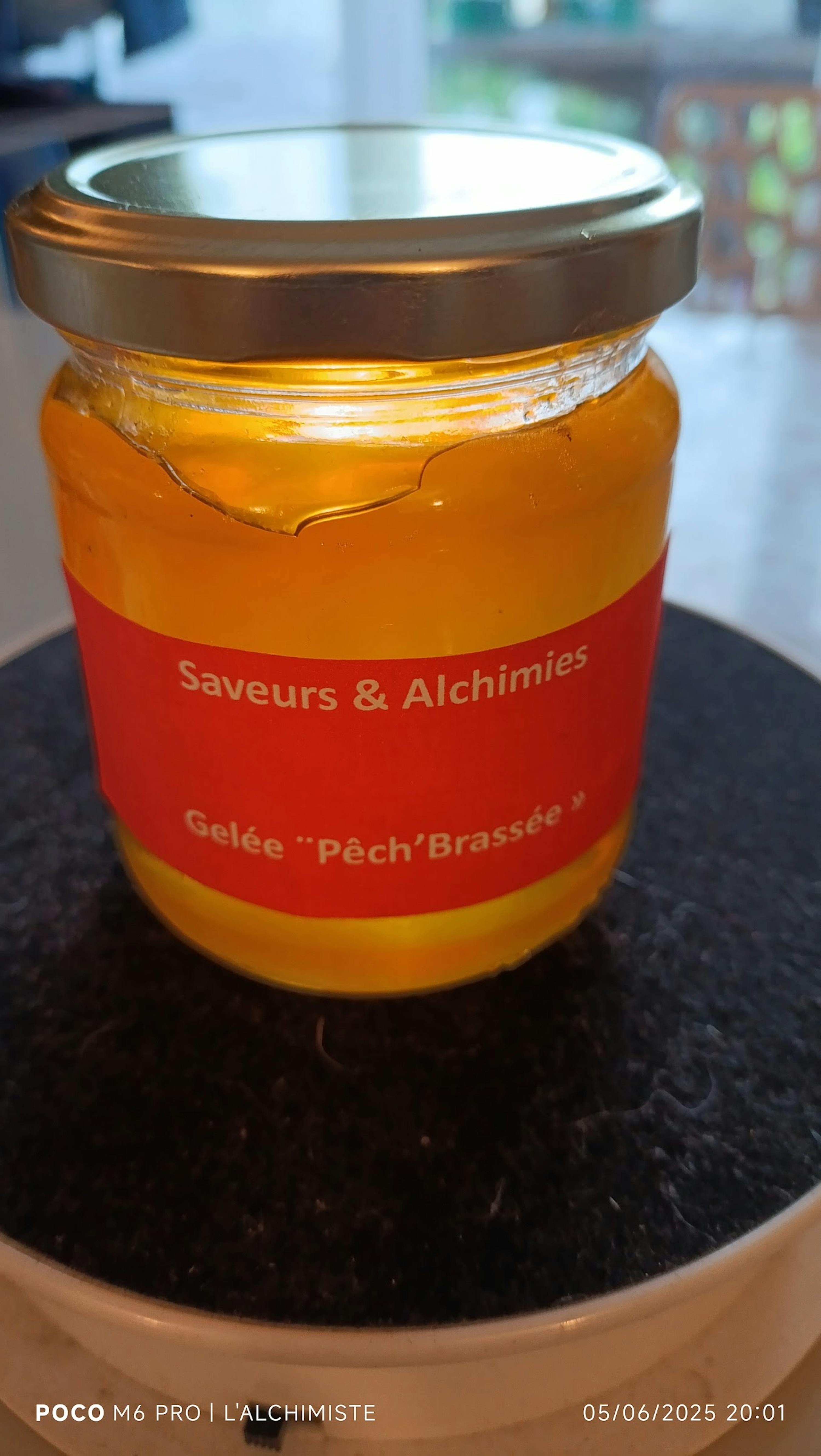 a jar of savours & alchimies gelee is on a table