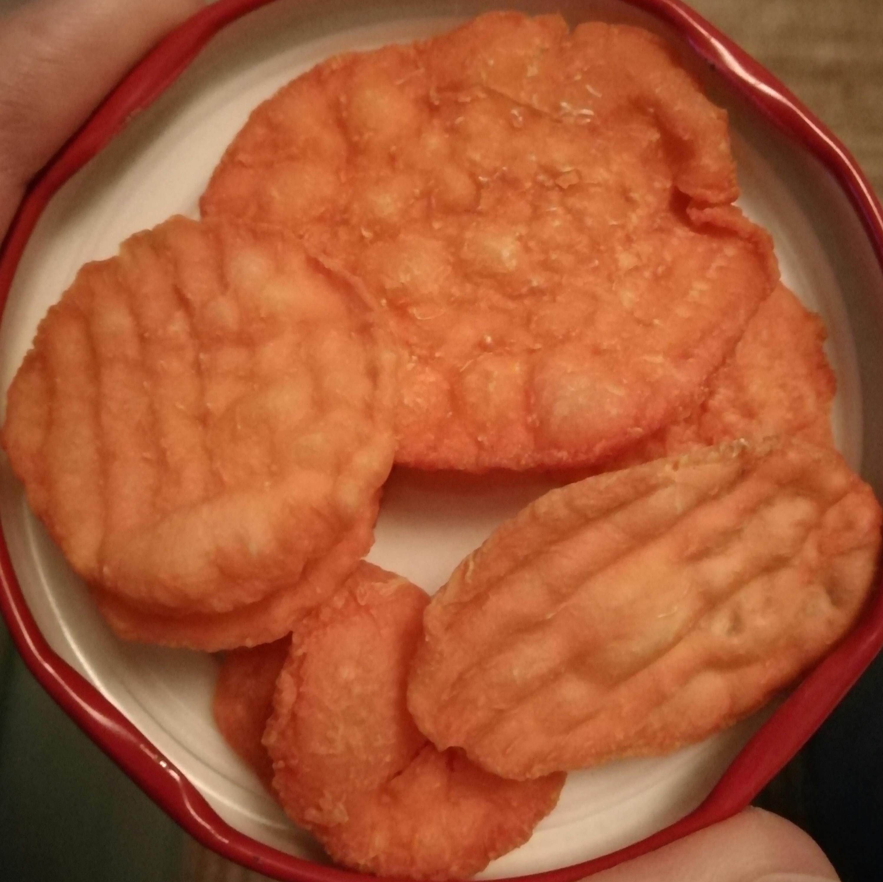 a person is holding a bowl of fried potato chips