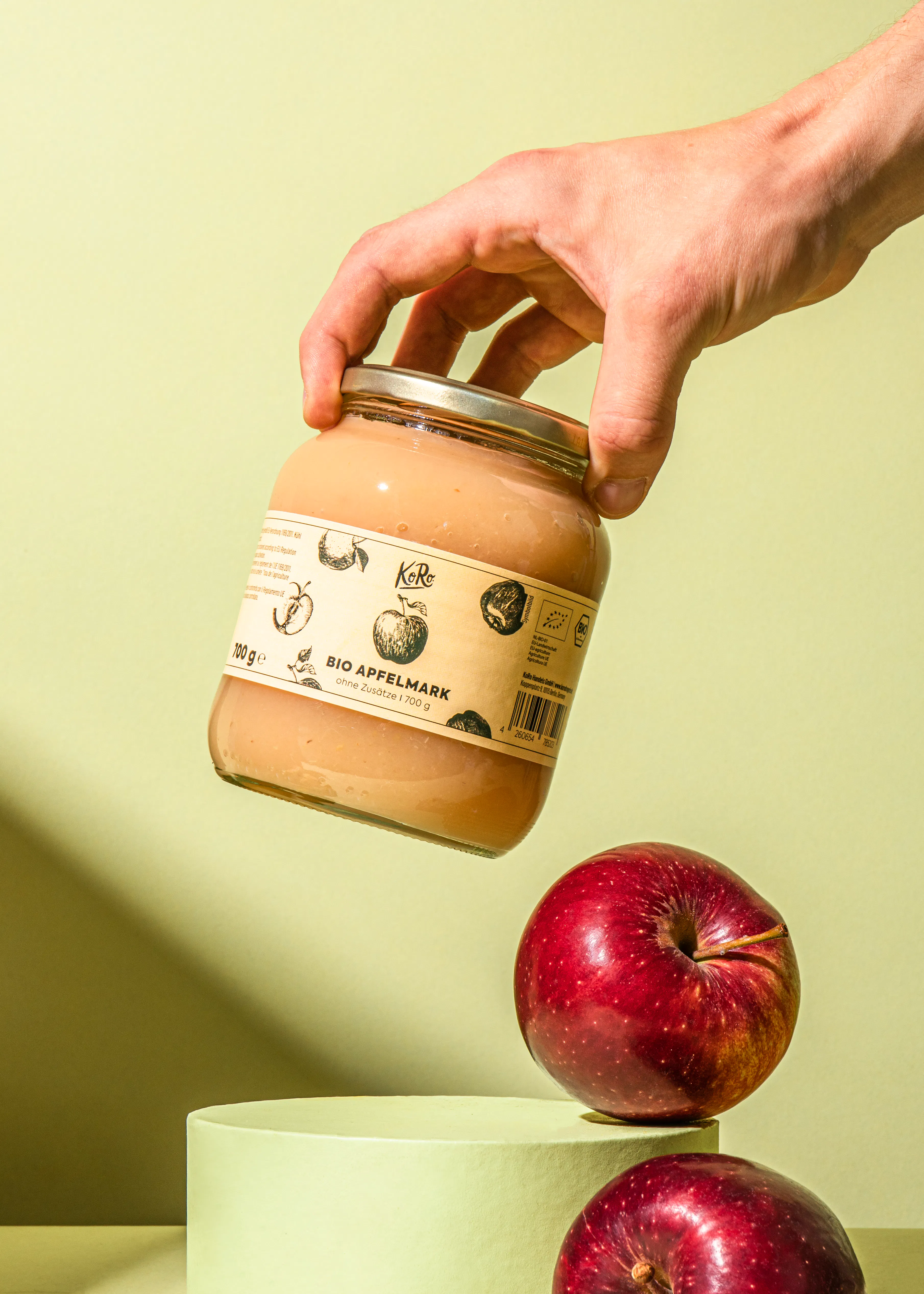 eine Person hält ein Glas Bio-Apfelmark in der Hand