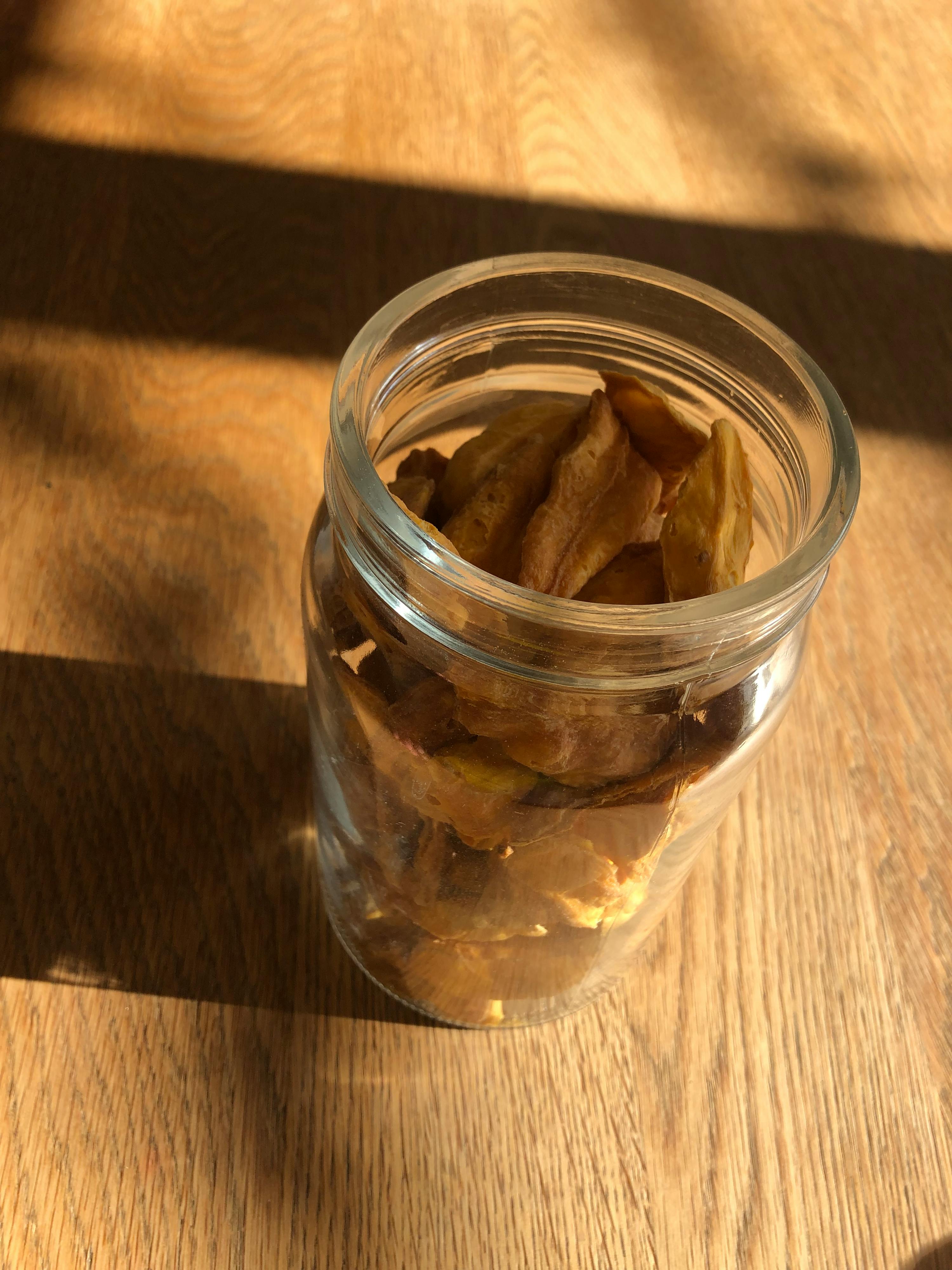 a glass jar filled with chips sits on a wooden table