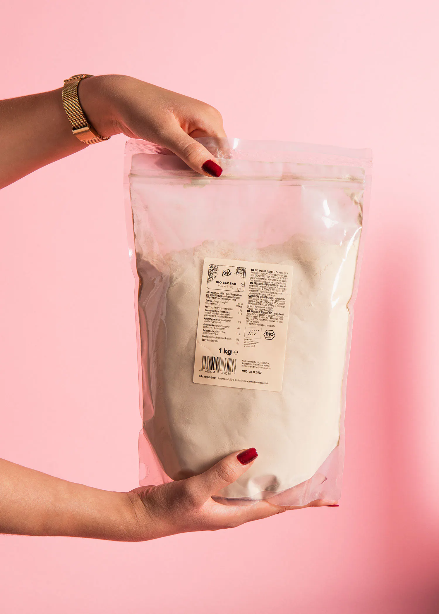 une personne tient un sac de farine blanche avec une étiquette blanche